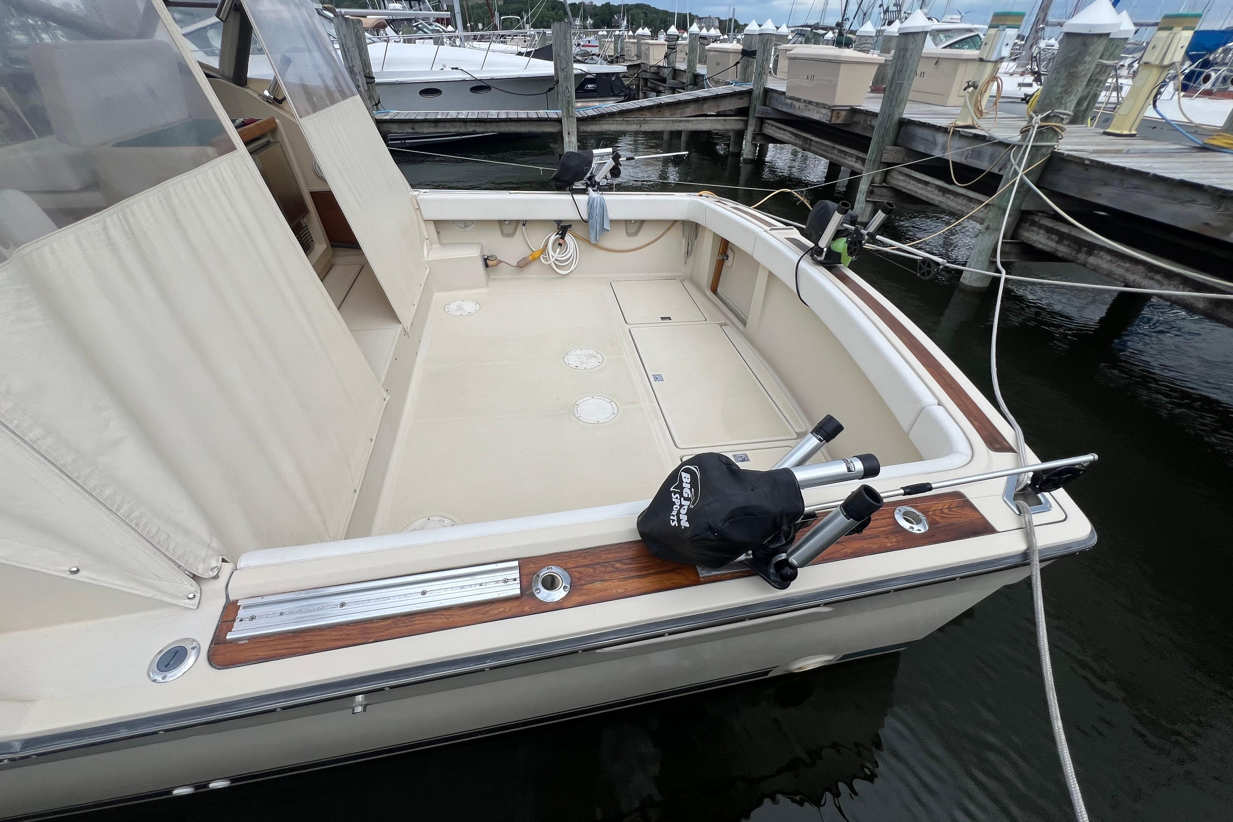 1985 Tiara 36 OPEN boat docked, featuring spacious deck and fishing rod holders.