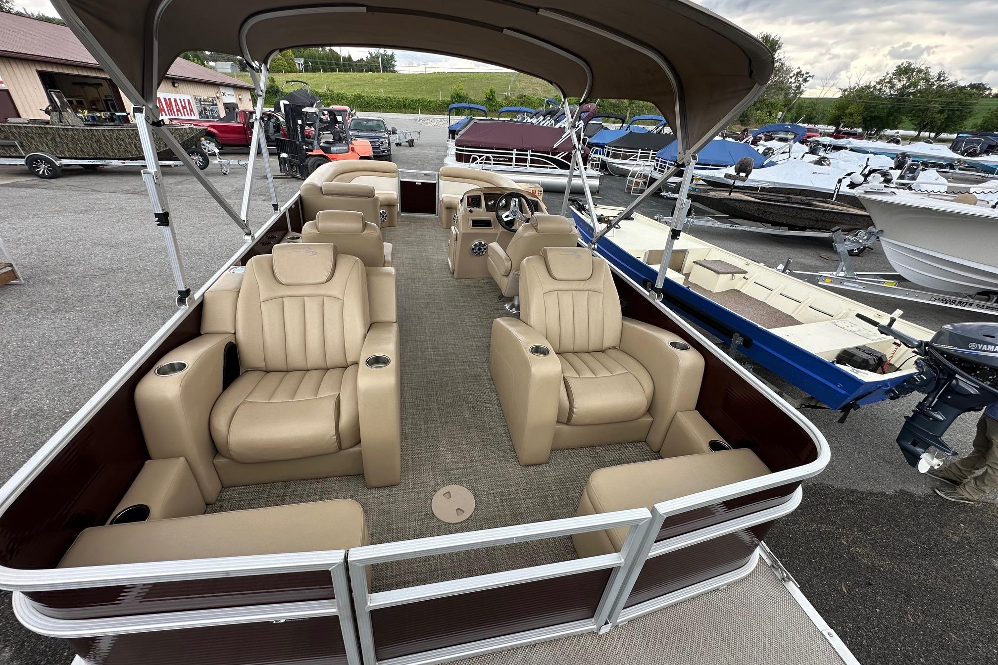 2016 Bennington 24 SCWX pontoon boat with beige seating and canopy, displayed outdoors.
