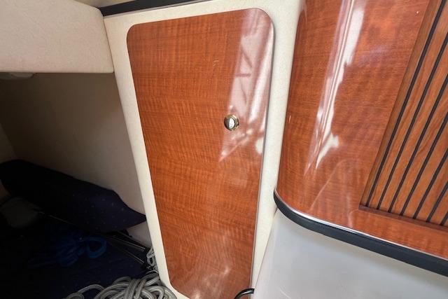2003 Sea Ray 260 Sundancer cabin interior with wood finish and storage compartment.