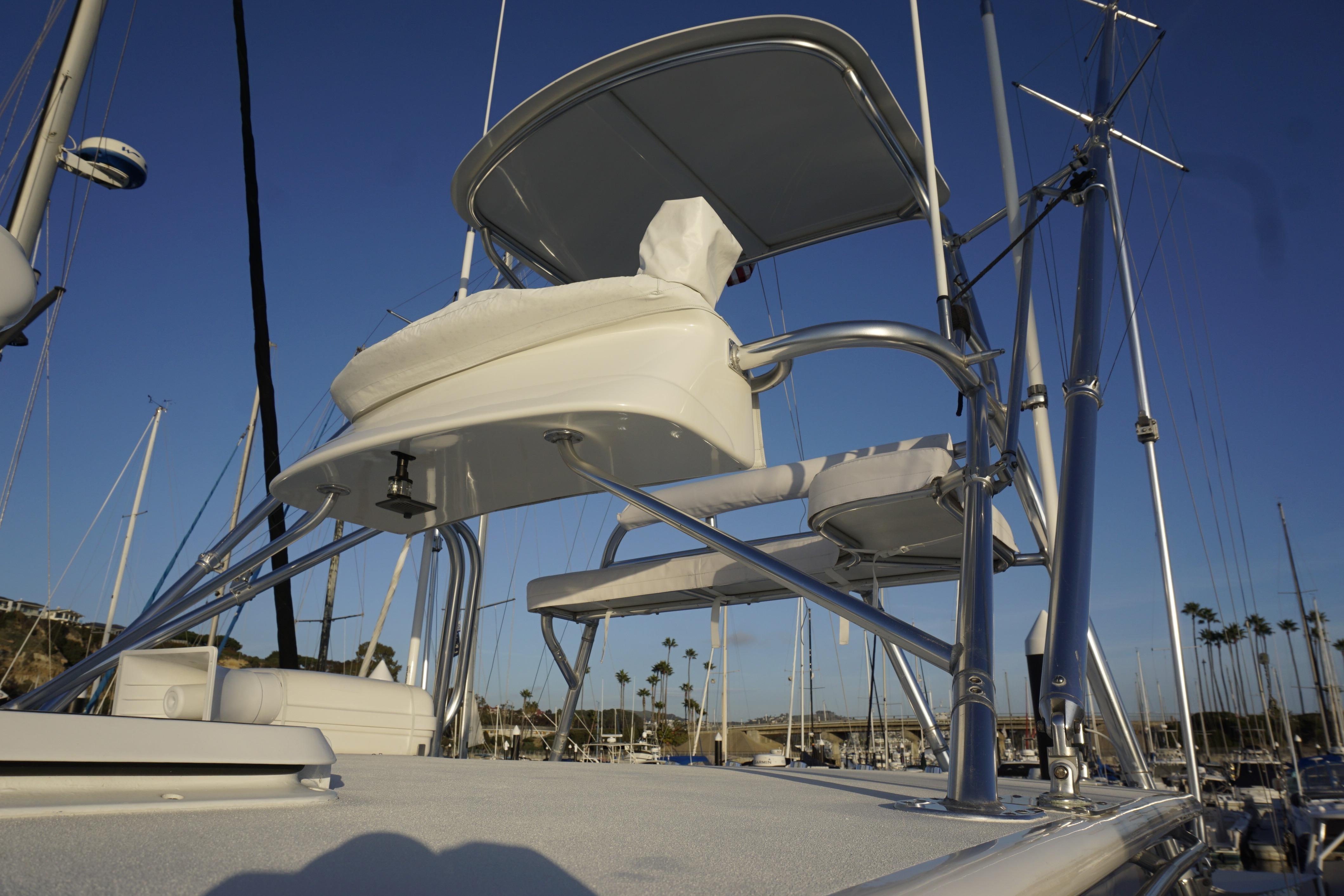 2005 Cabo 35 Express boat with elevated seating and marina backdrop.