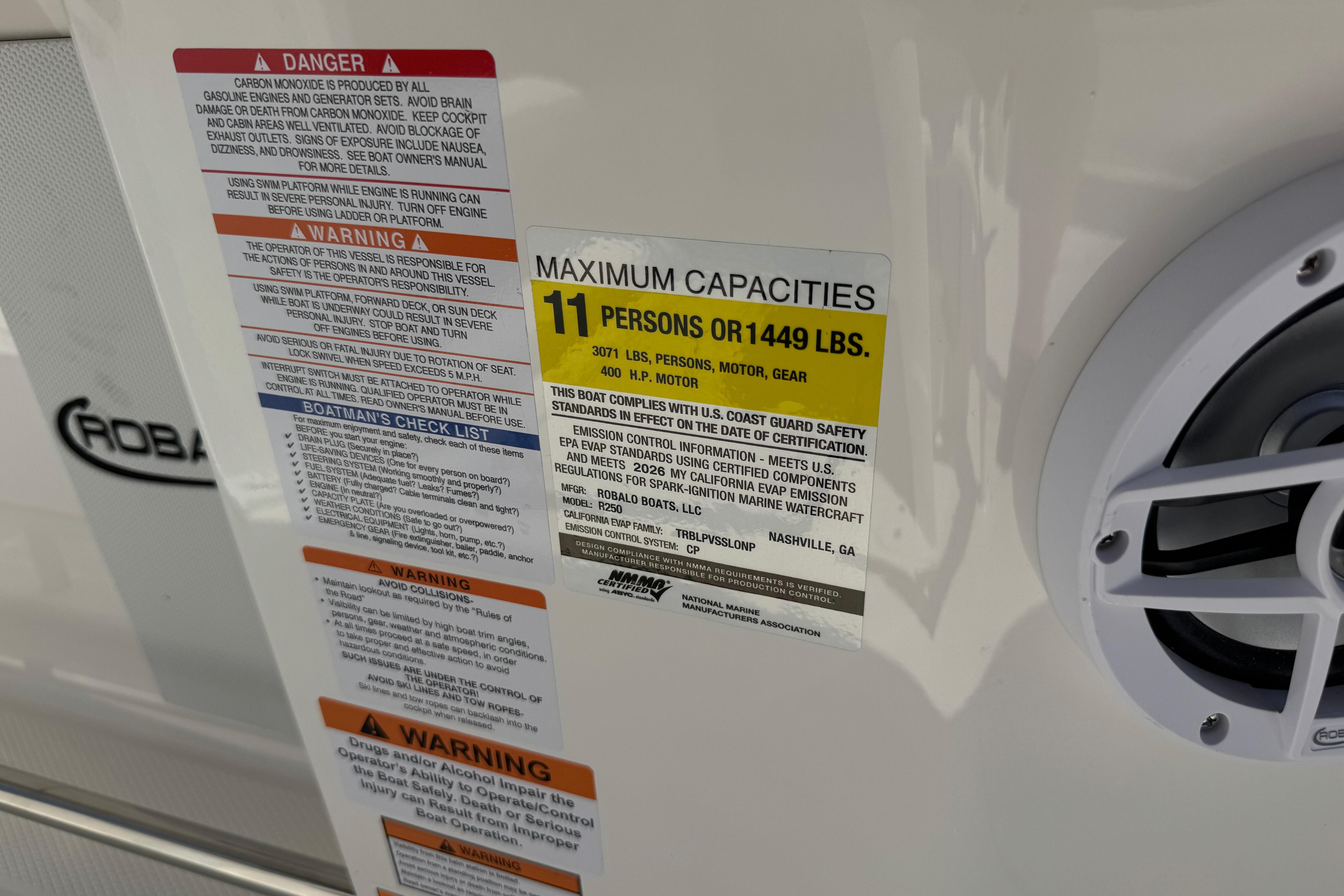 Warning labels and capacity information on a 2026 Robalo R250 Center Console boat.