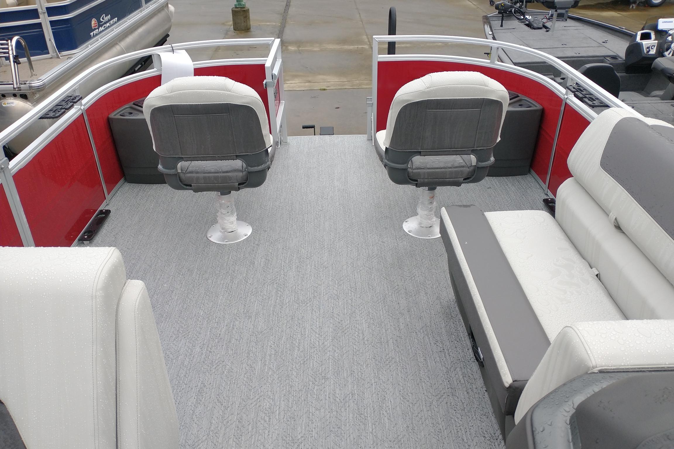 2026 Sun Tracker Fishin' Barge 22 DLX interior with seating and red paneling.