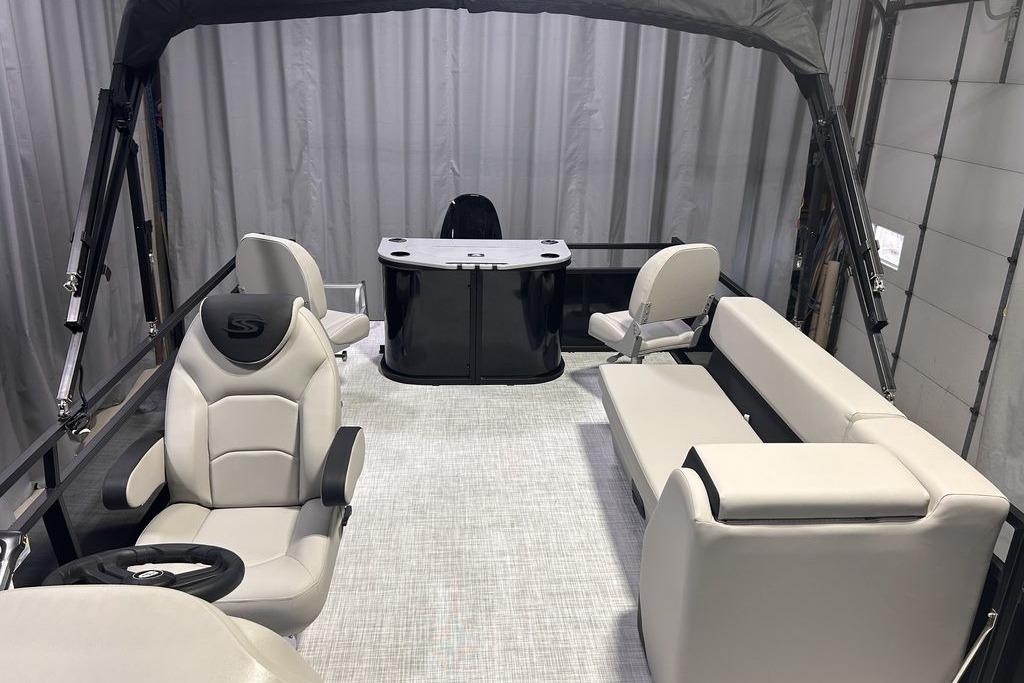 2026 Dockside 22DF boat interior with modern seating and steering wheel, under a canopy.