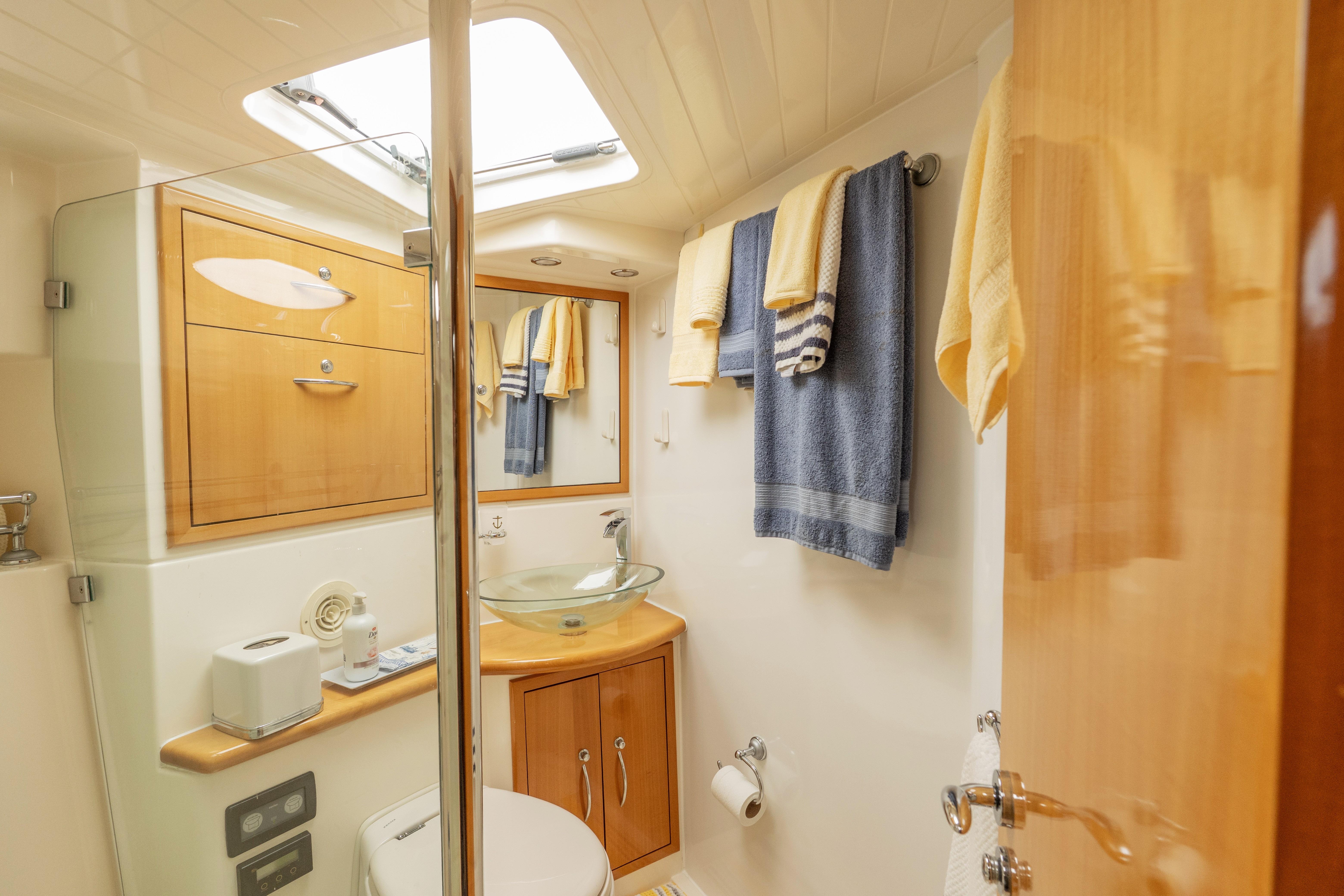 Luxurious bathroom in a 2008 Maritimo 52 yacht, featuring modern fixtures and elegant wood cabinetry.