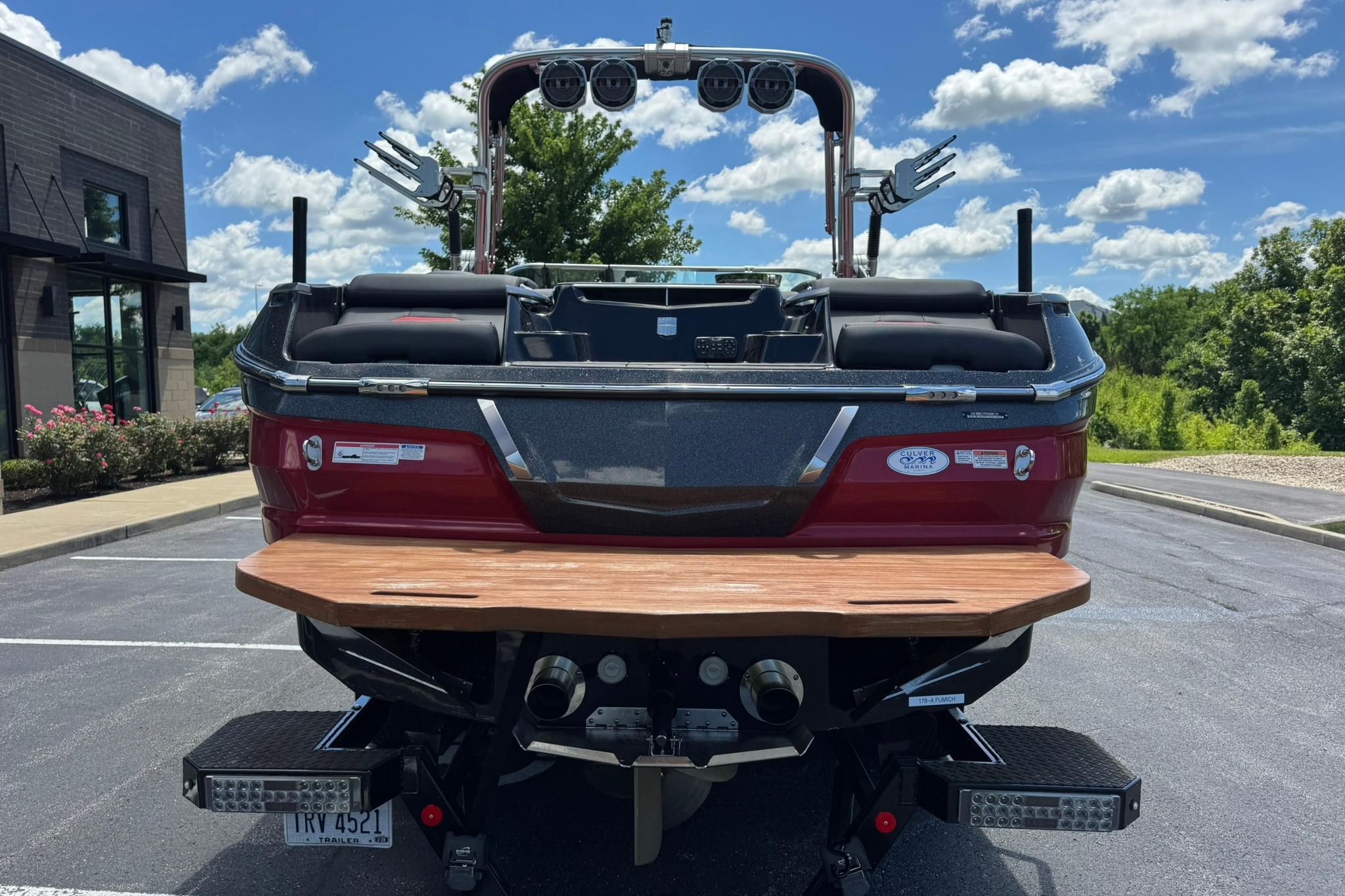 2021 MasterCraft X26 boat, rear view, parked outdoors under a clear blue sky.