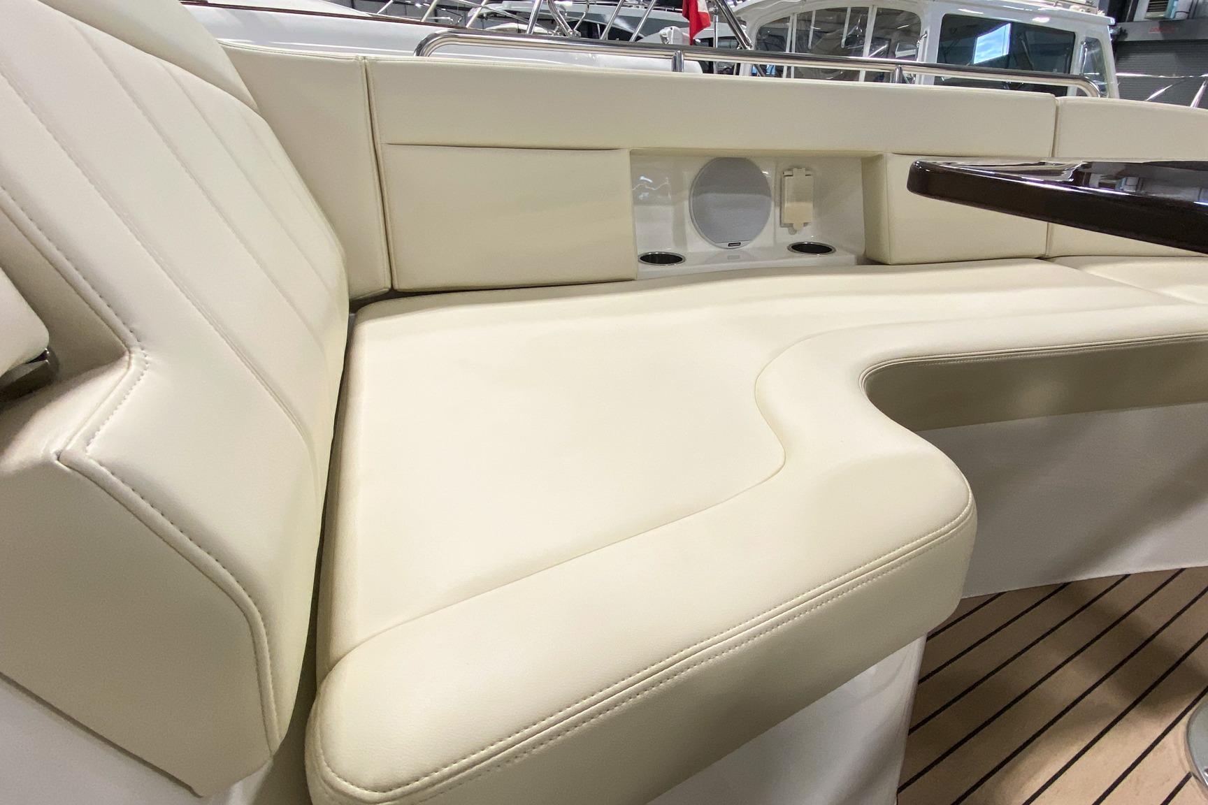 Luxurious seating on 2022 MJM 3 boat with cream upholstery and wooden accents.