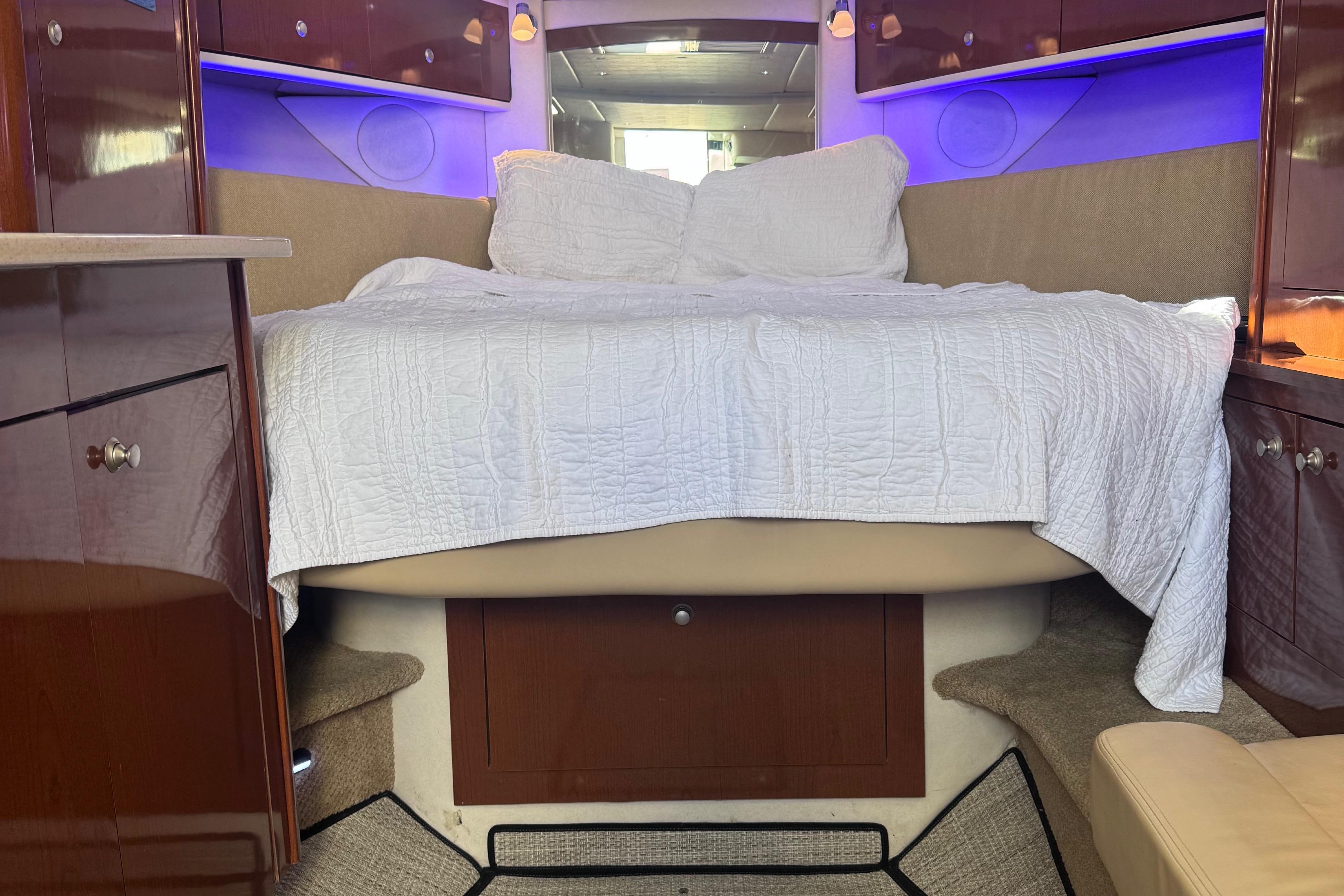 Luxurious cabin interior of 2008 Sea Ray 350 Sundancer with cozy bed and ambient lighting.