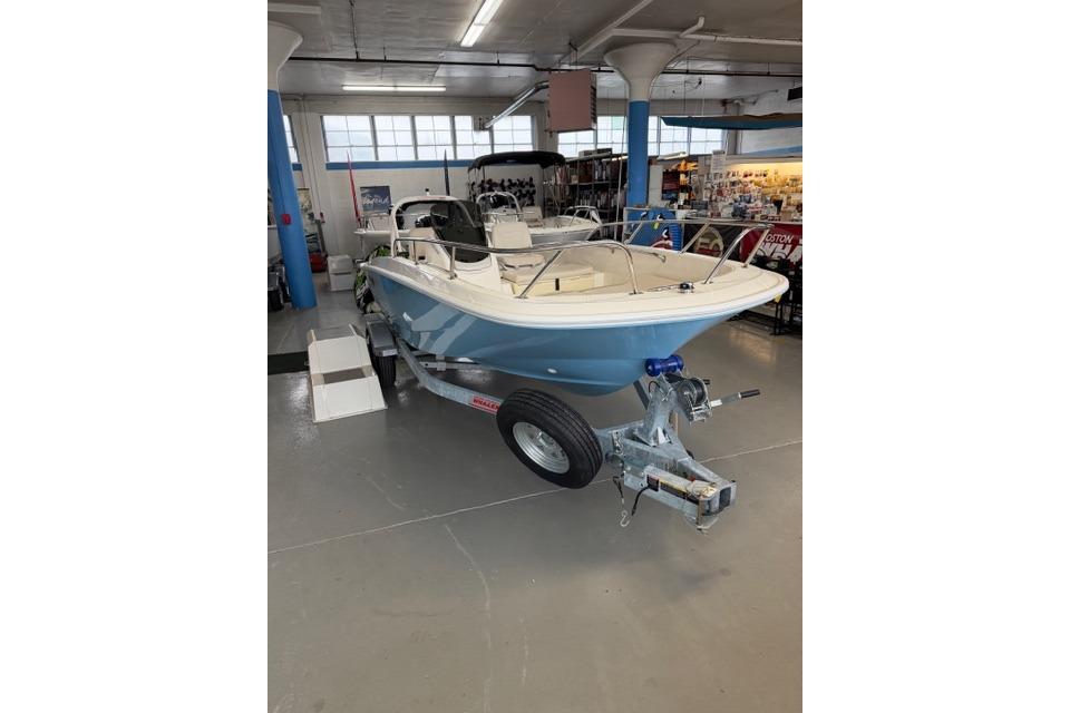 2026 Boston Whaler 160 Super Sport boat displayed indoors on a trailer.