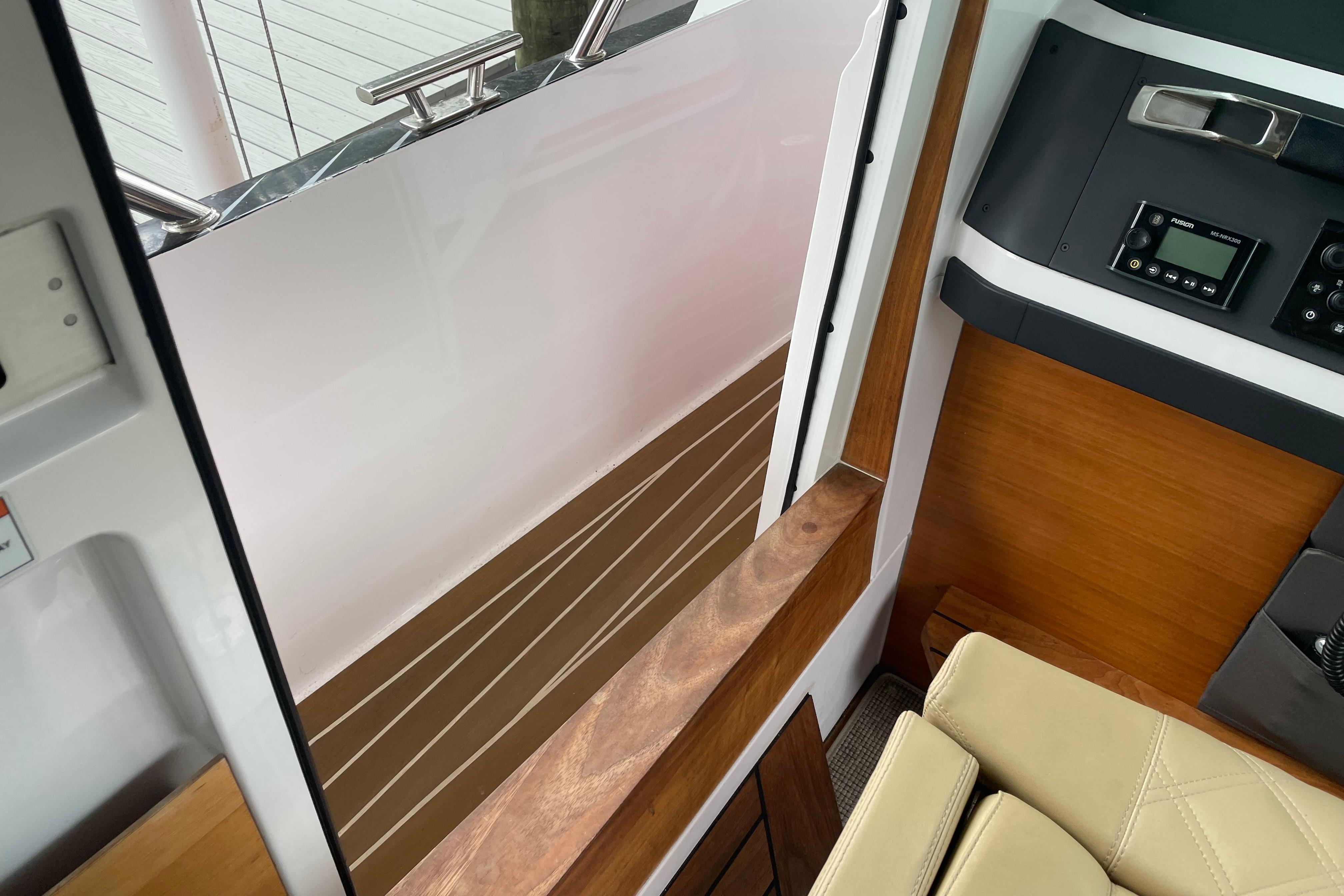 Interior view of 2021 Axopar 28 Cabin, featuring wood accents and control panel.