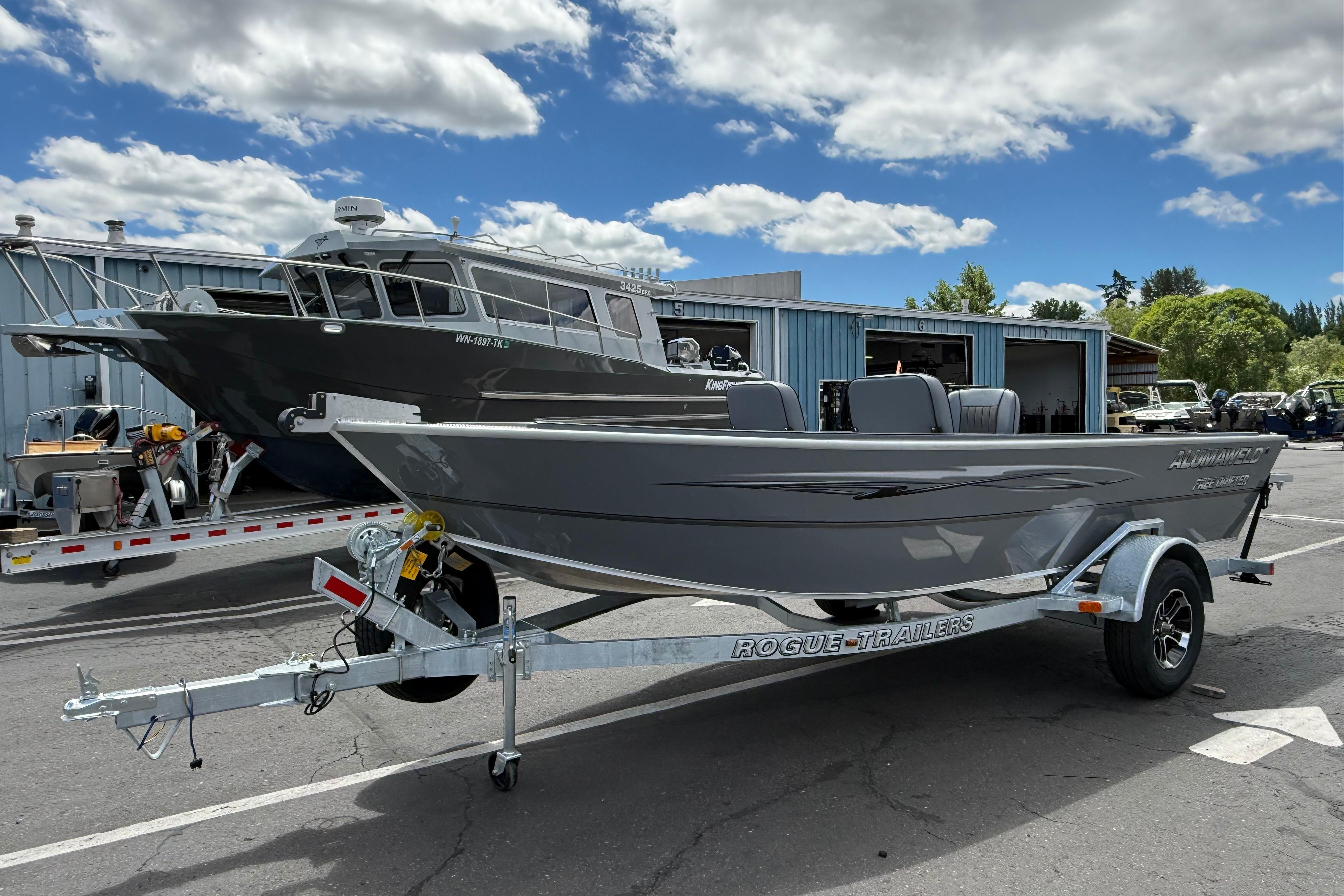 2026 Alumaweld Free Drifter 20 boat on Rogue trailer, parked outdoors under cloudy sky.