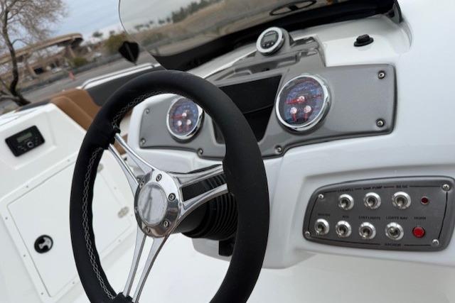 Steering wheel and dashboard of 2026 Tahoe 1950 boat, featuring modern controls and gauges.