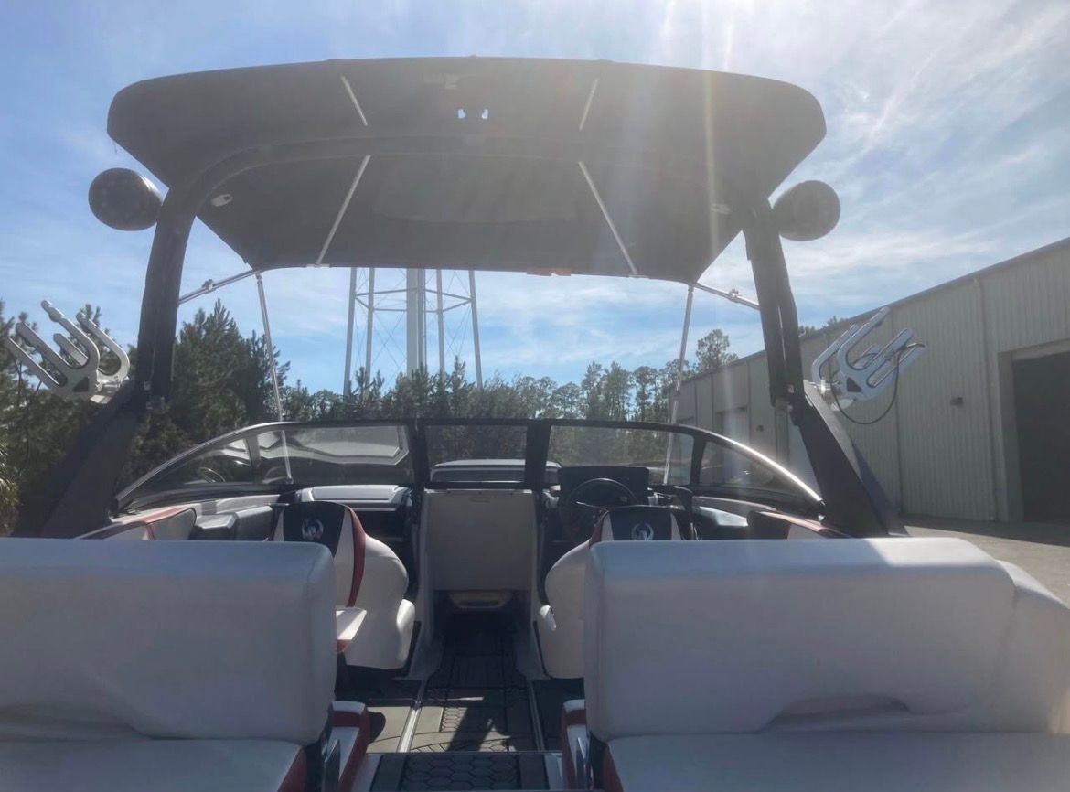 The image shows the cockpit of a 2017 Scarab 215 boat with two white seats.