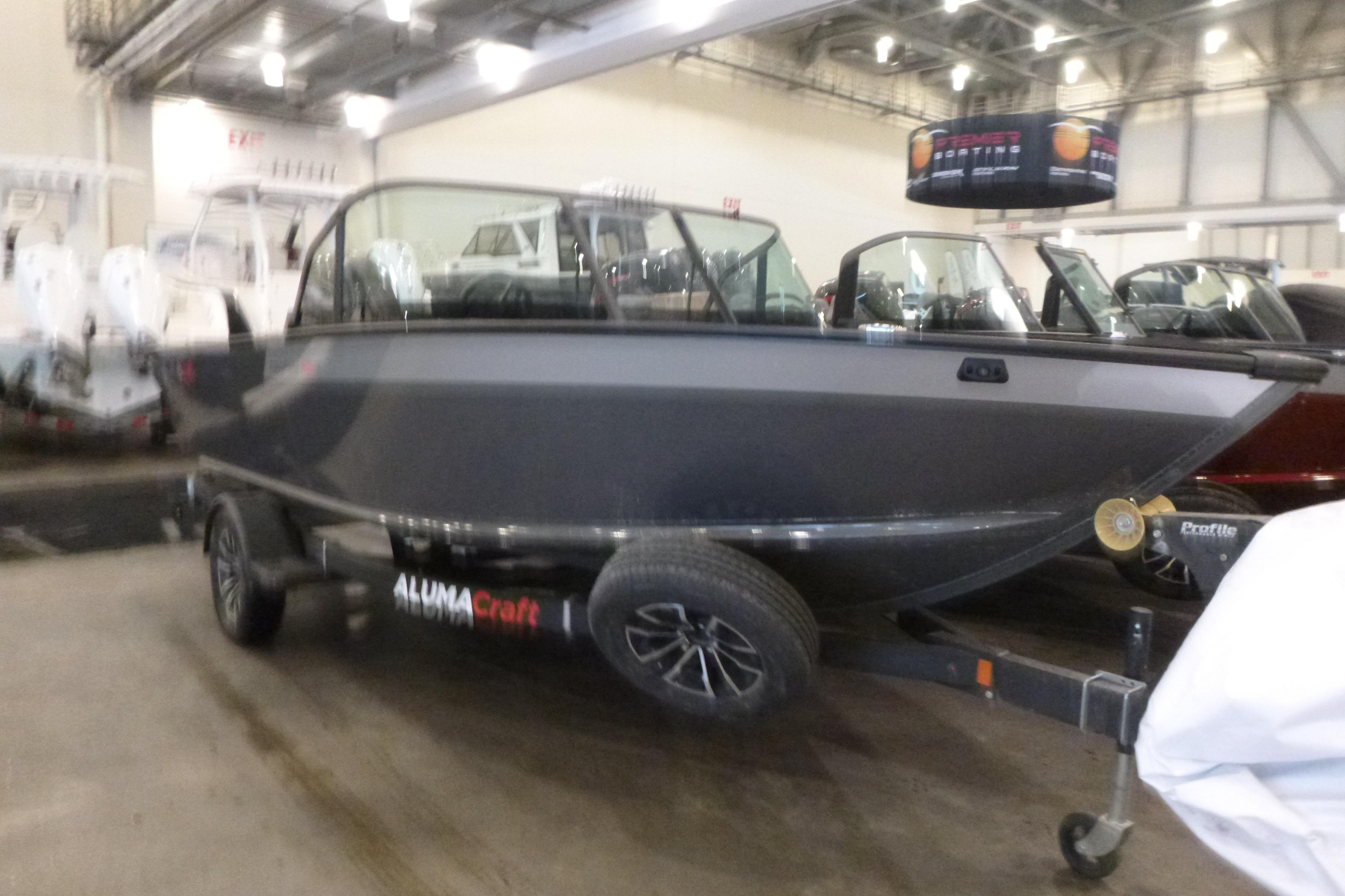 2025 Alumacraft Trophy 185X Sport boat displayed indoors on a trailer.