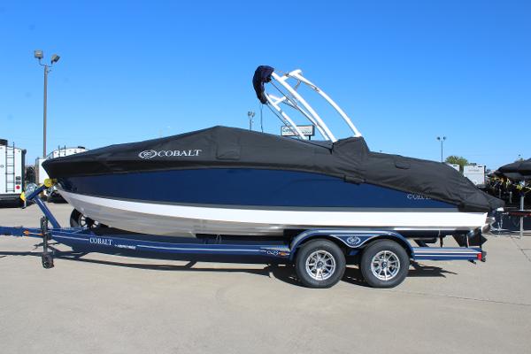 2025 Cobalt CS23 boat on trailer with cover, parked outdoors.
