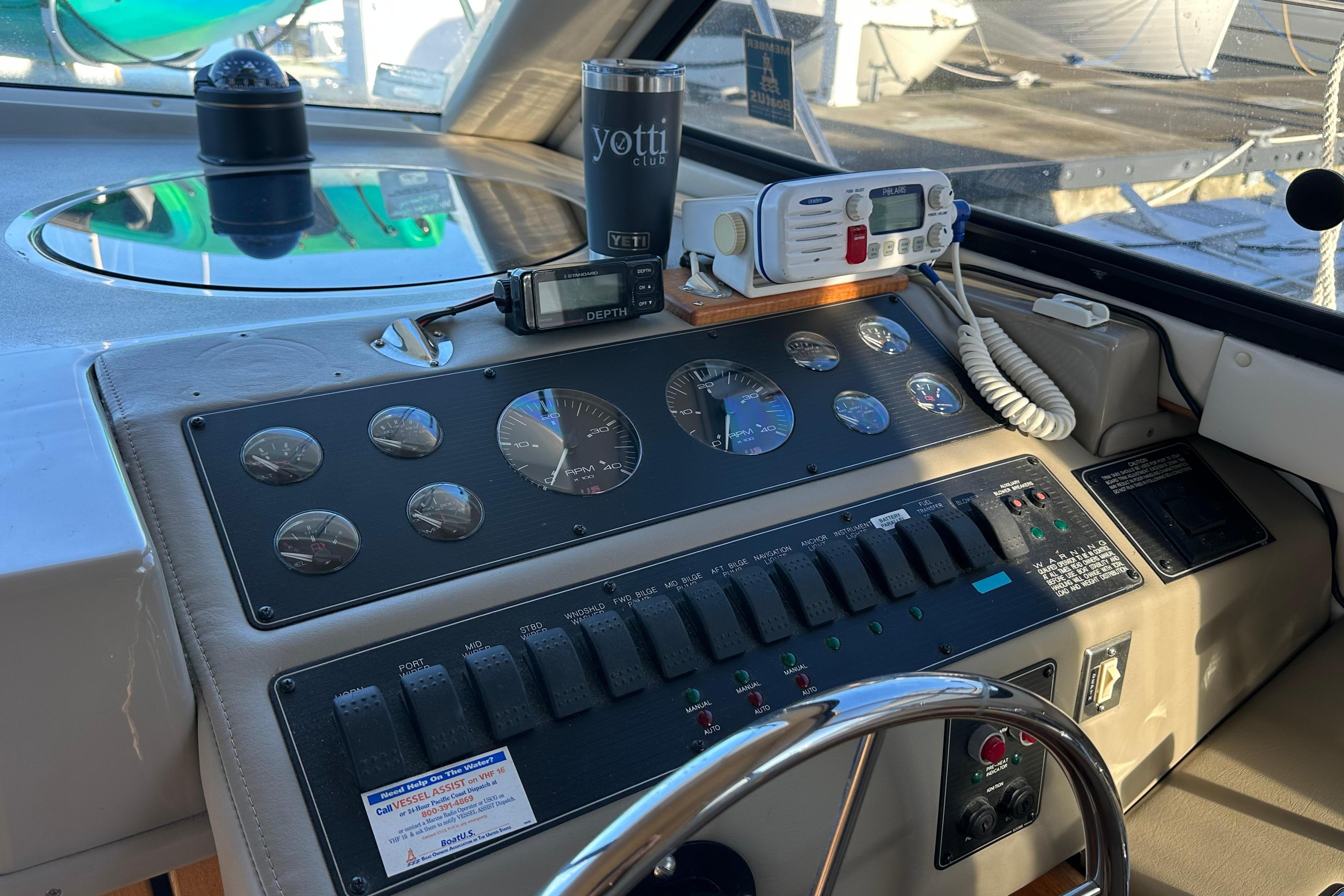 Control panel of a 2000 Bayliner 4087 Aft Cabin Motoryacht with gauges and radio equipment.