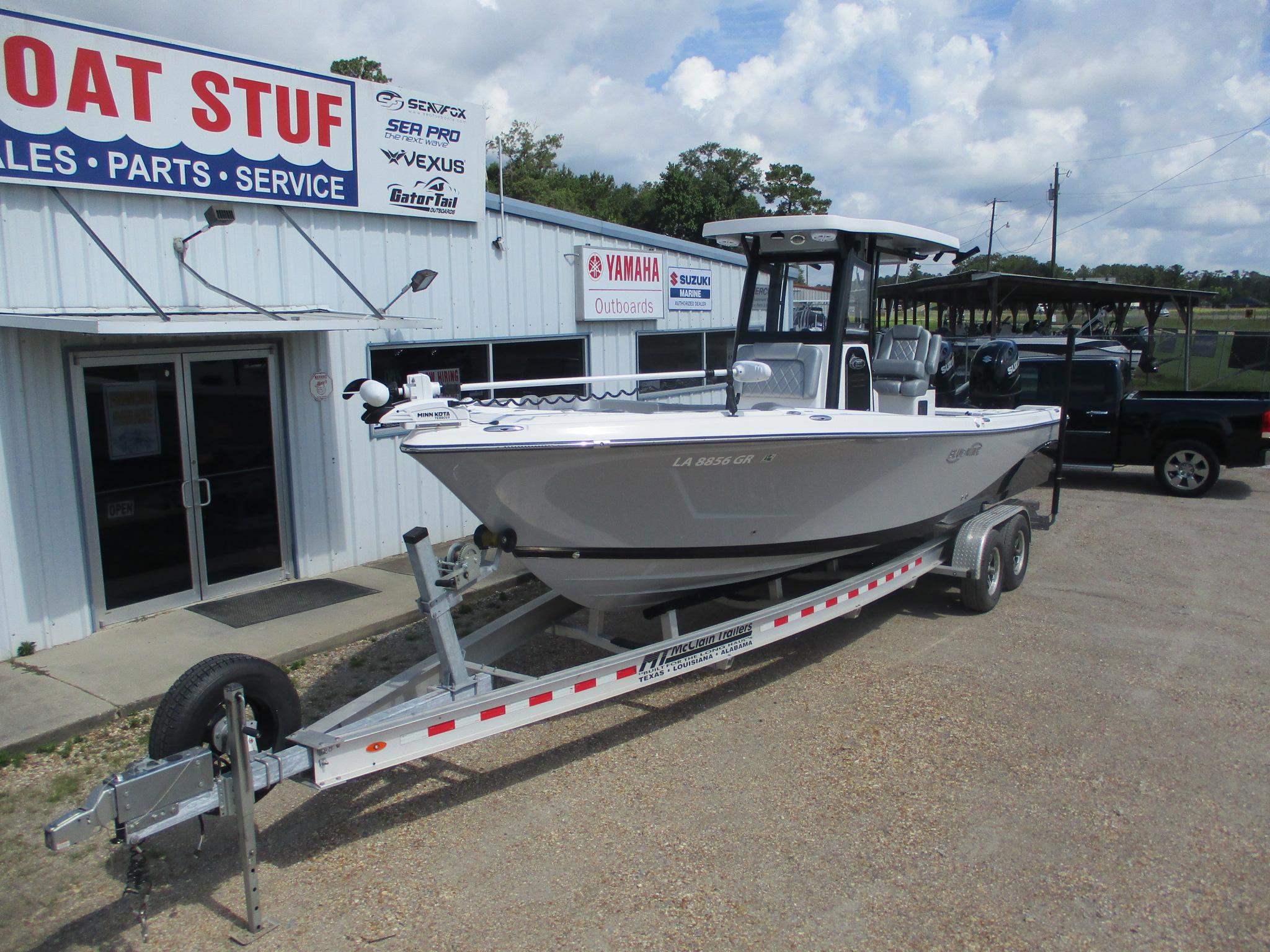 2024 Blue Wave 2800 Makaira boat on trailer outside dealership.