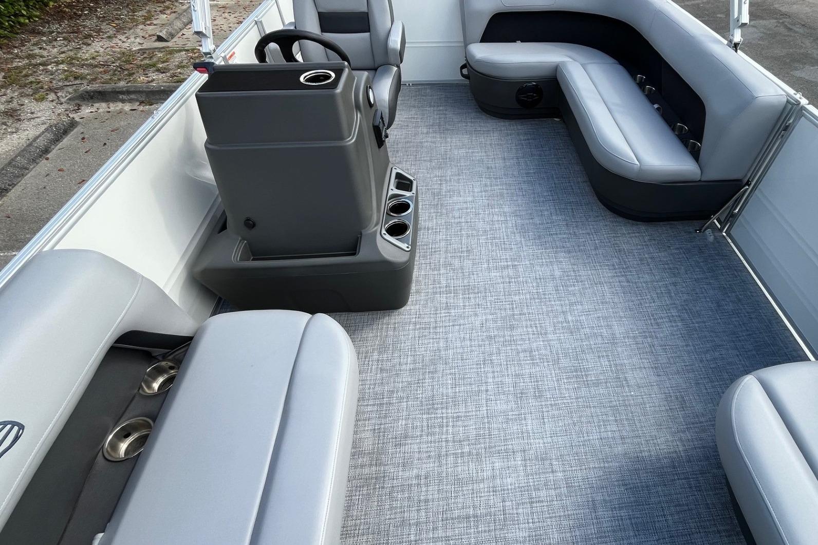 2026 Sun Tracker Party Barge 16 DLX interior with gray seating and modern console.