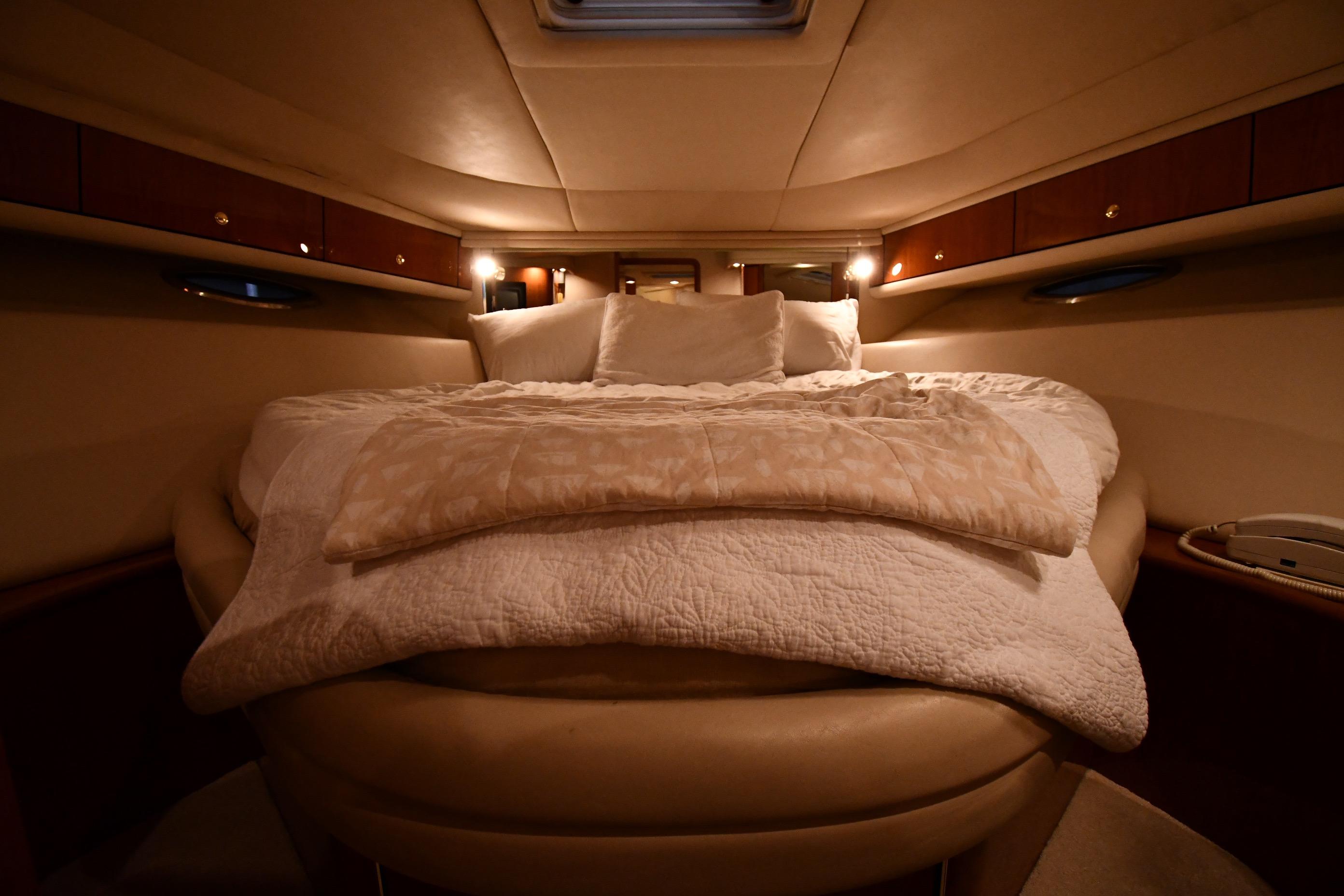 Luxurious cabin interior of 2001 Sea Ray 540 Sundancer yacht with cozy bedding.