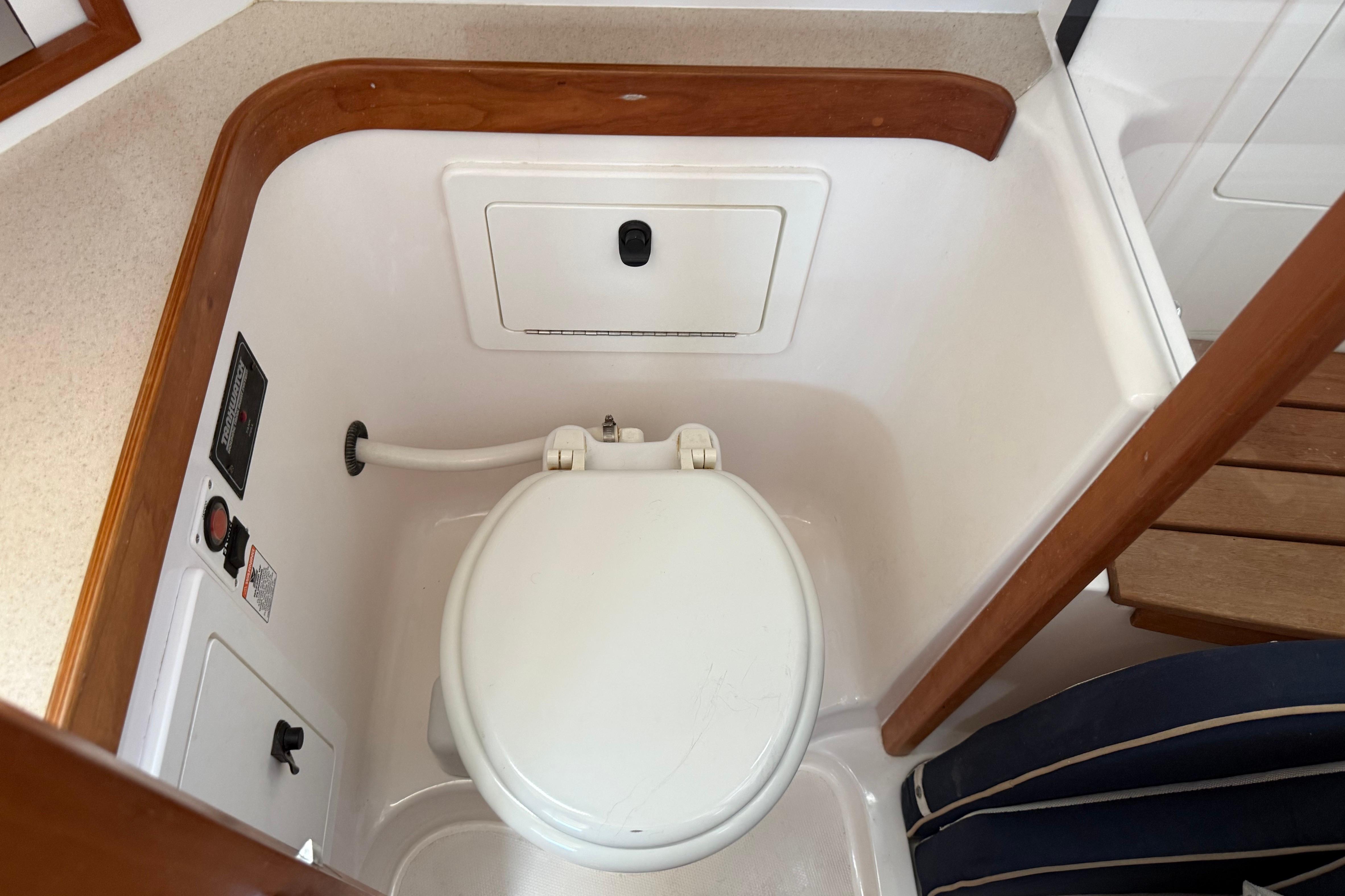 2004 Sabre 386 yacht bathroom with compact marine toilet and wooden accents.