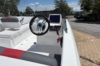 2026 Tahoe T16 boat interior with steering wheel and seating, parked outdoors.