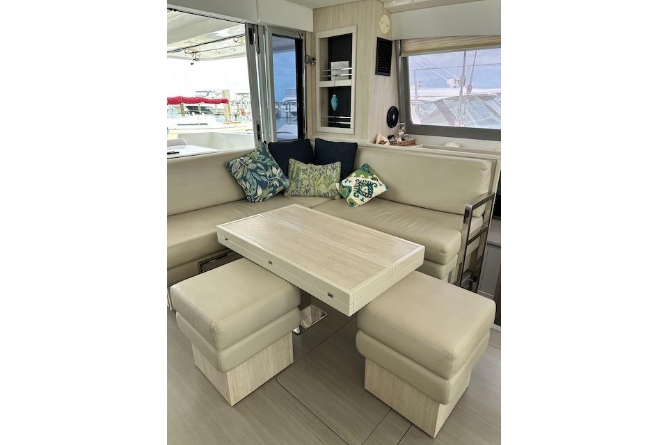 Interior of 2017 Leopard 40 catamaran with beige seating, table, and decorative pillows.
