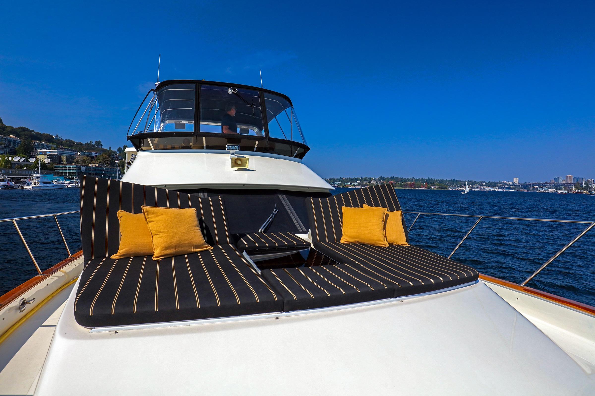 1987 Ocean Alexander 480 Sport Sedan yacht with striped cushions and scenic waterfront view.