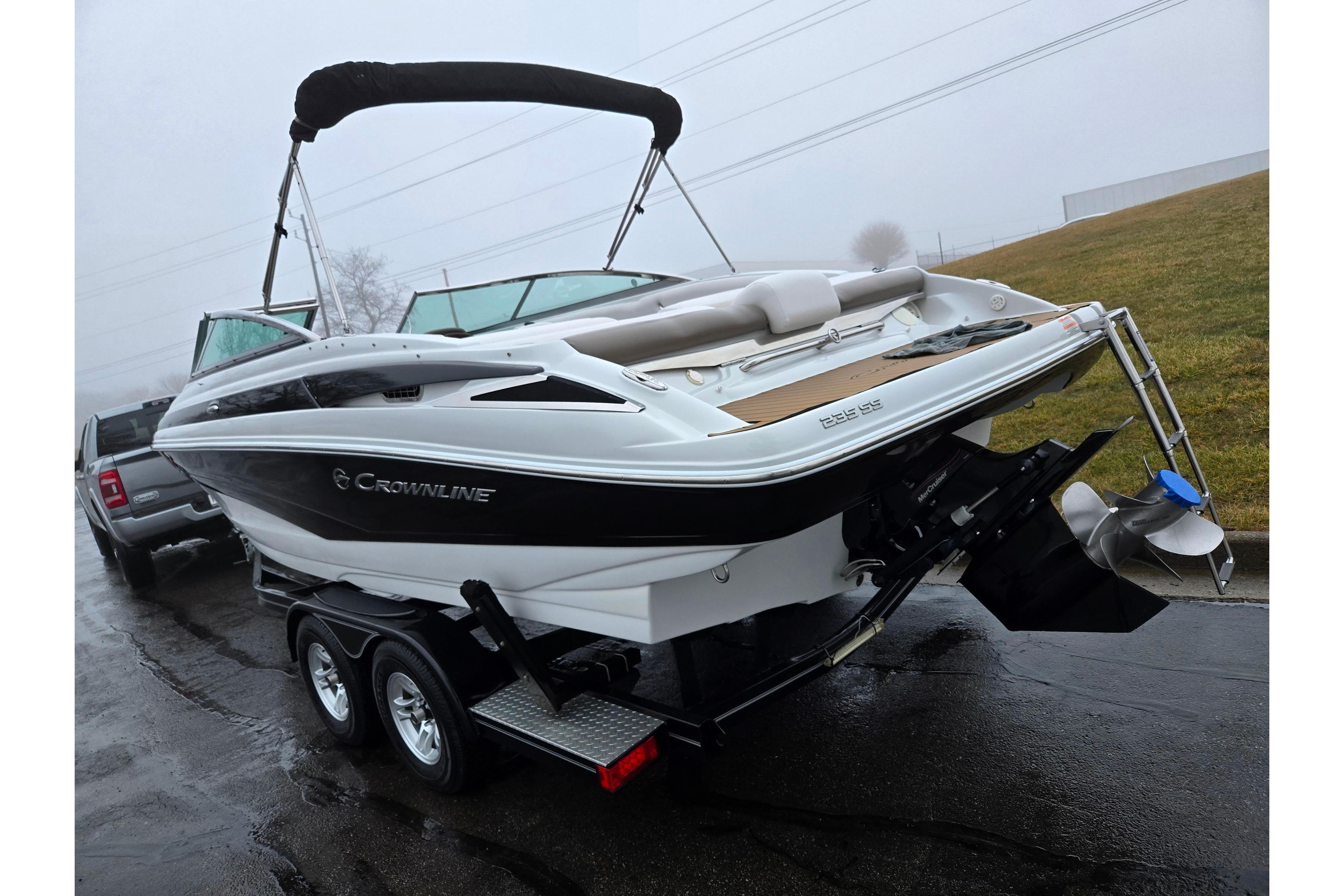2012 Crownline 235 SS boat on trailer, parked on wet pavement.