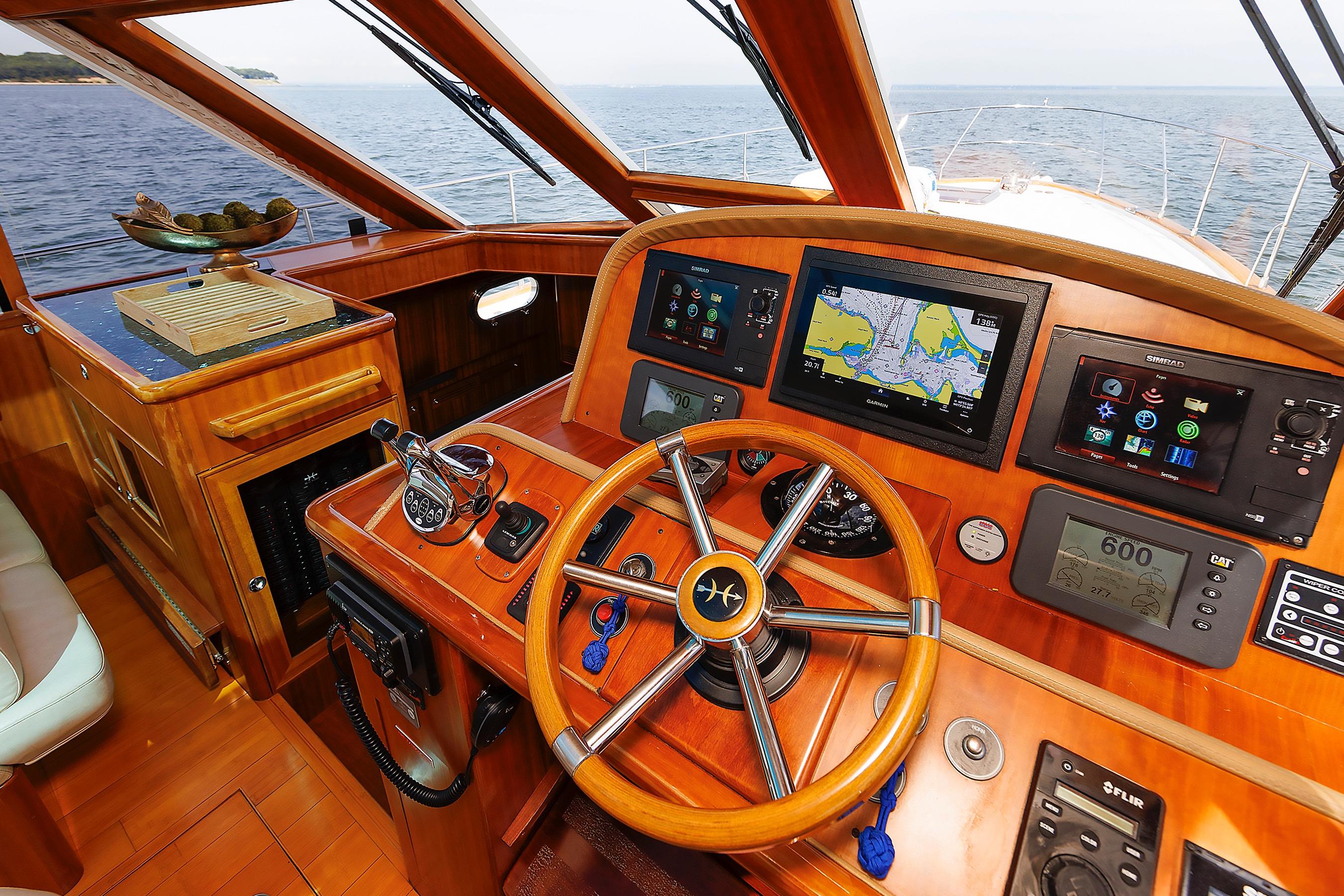 Helm of 2009 Hunt Yachts 52 Express with navigation screens and wooden steering wheel.