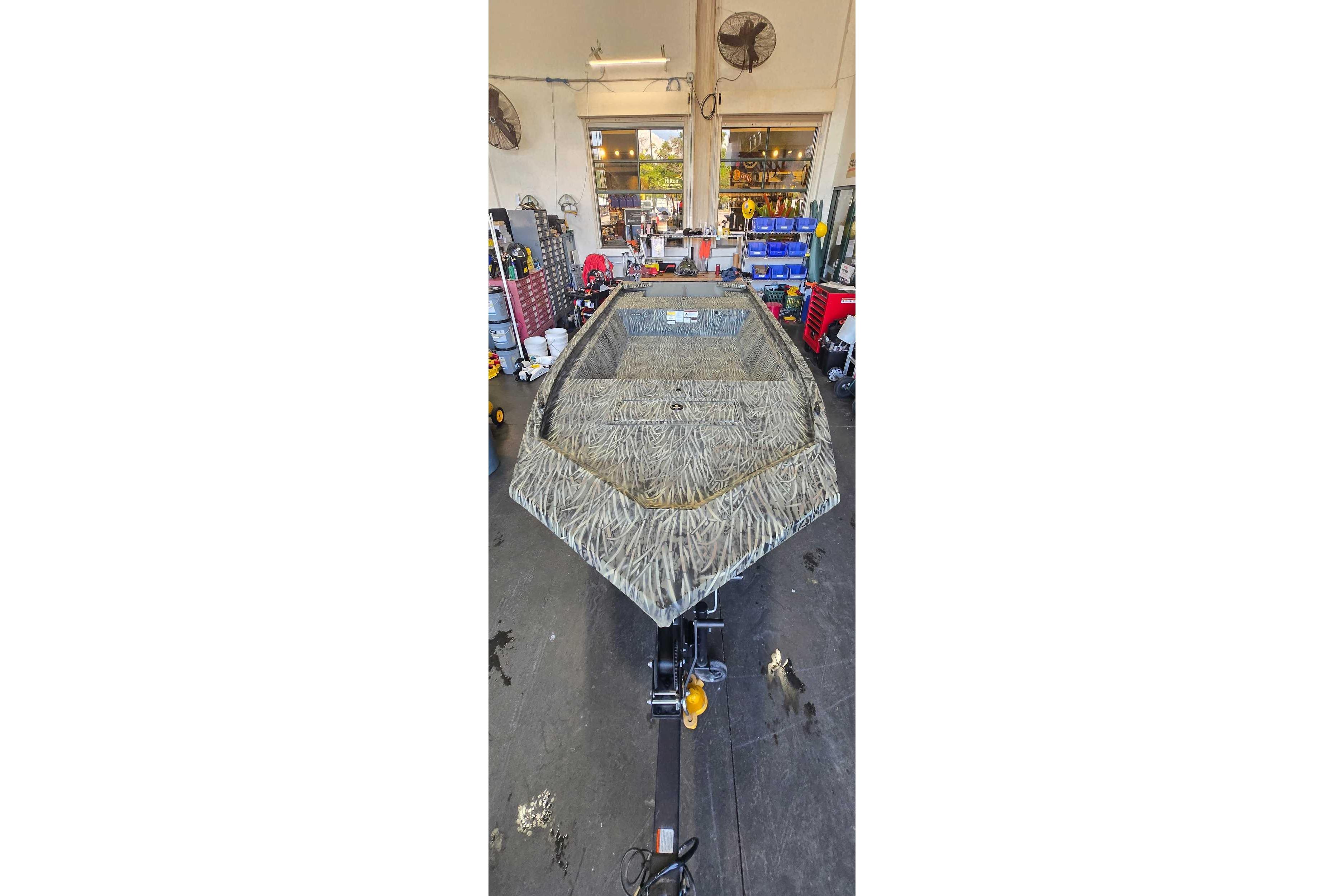 2026 Tracker Grizzly 1648 Utility boat in a workshop setting.