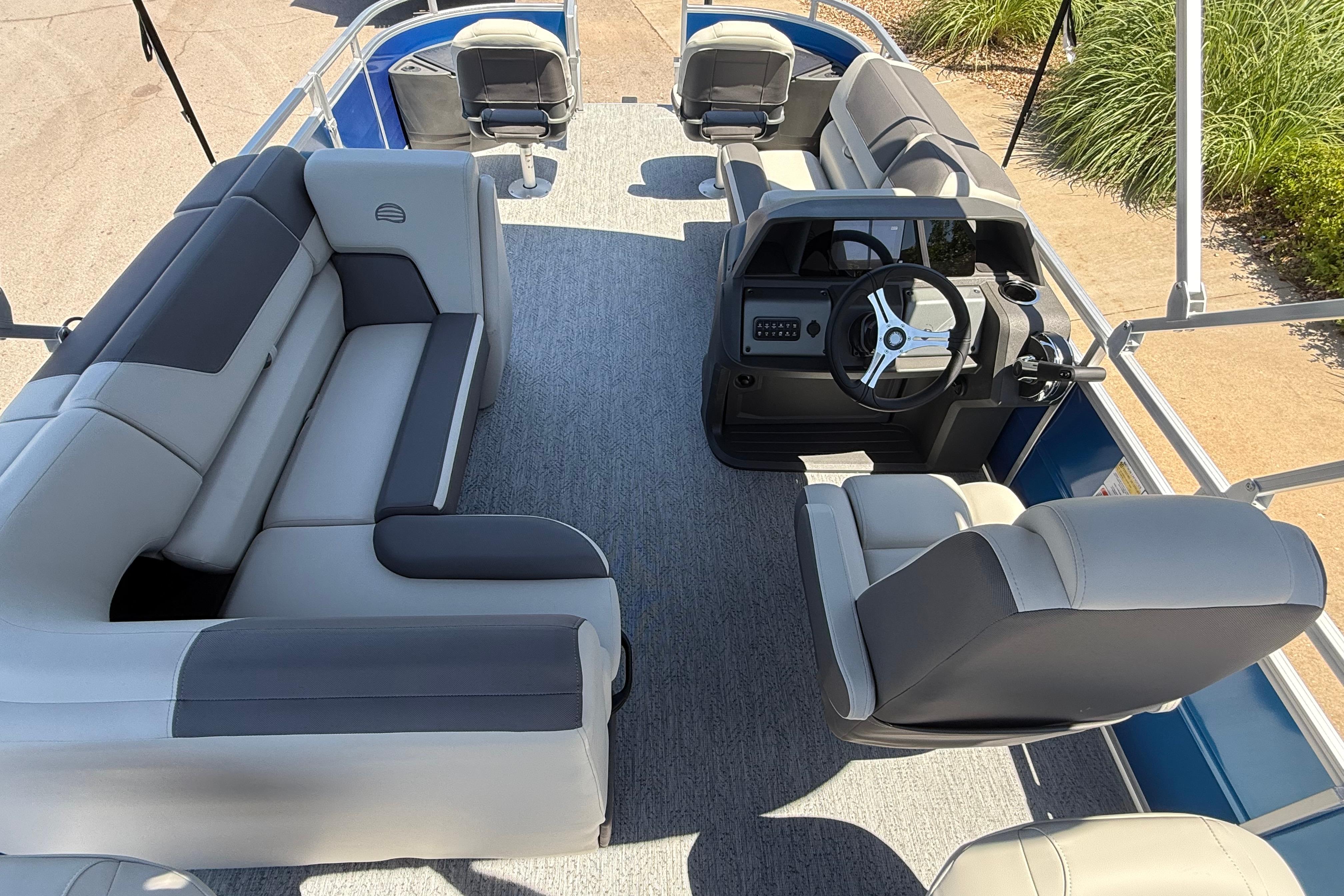 2026 Sun Tracker Fishin' Barge 20 DLX interior with plush seating and modern helm.