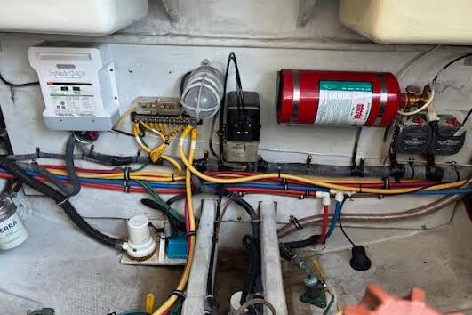 Engine compartment of a 2006 Chris Craft Corsair Heritage with wiring and fire extinguisher.