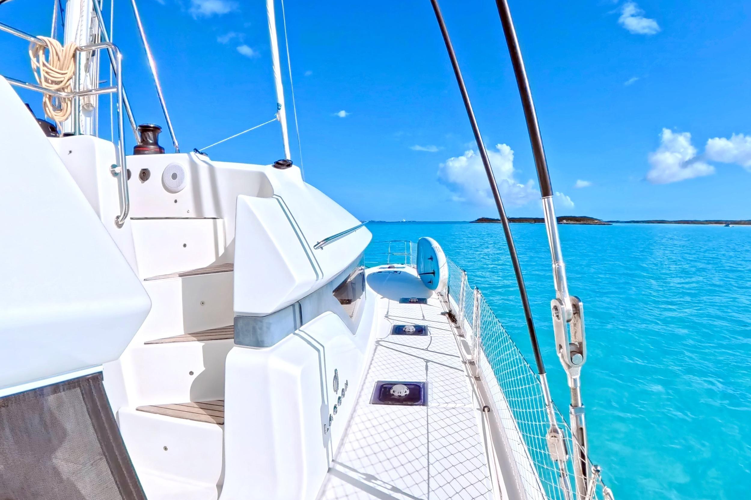 2023 Lagoon 50 yacht sailing on clear blue waters under a sunny sky.