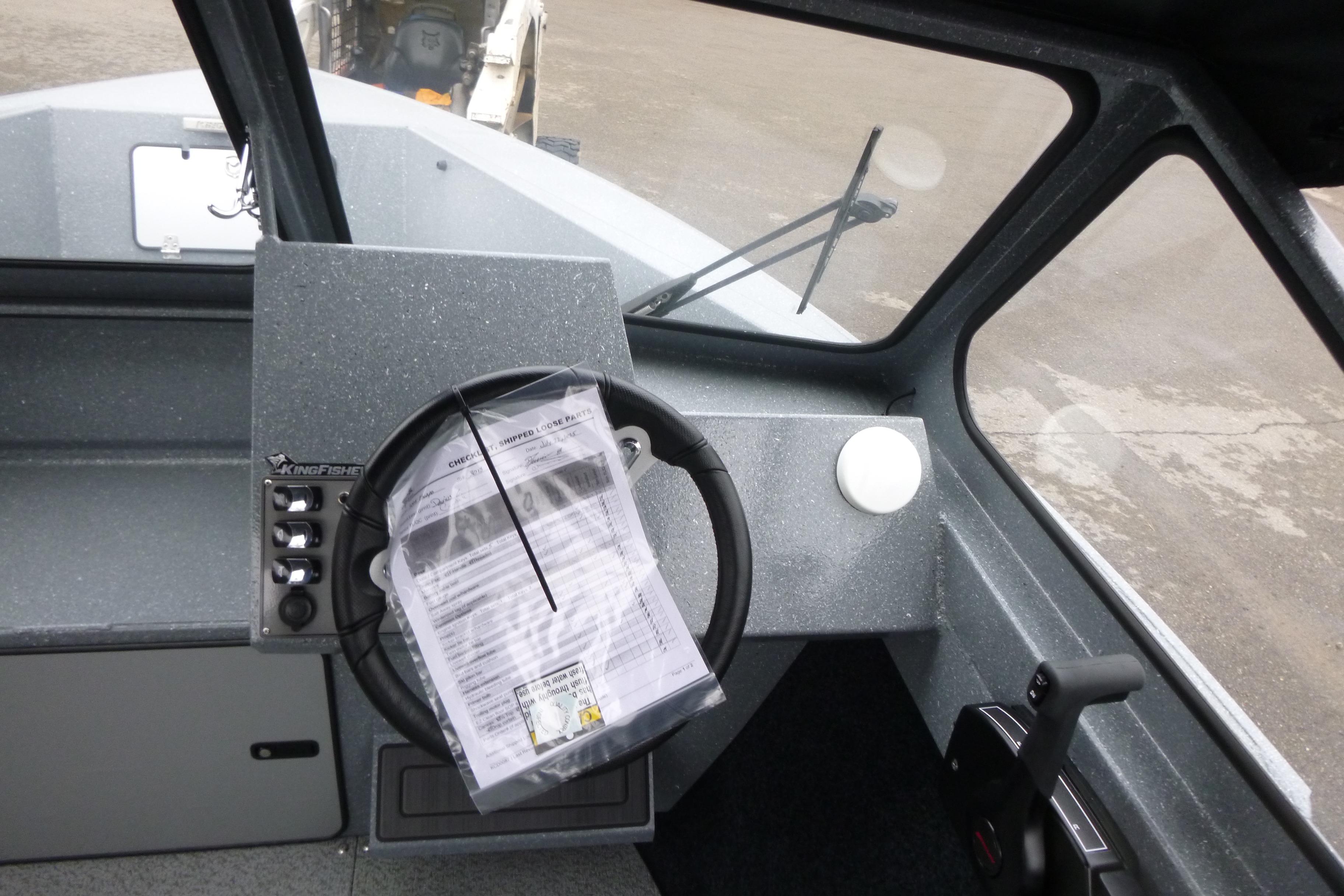 Interior of 2026 KingFisher 2025 Escape boat, featuring steering wheel and control panel.