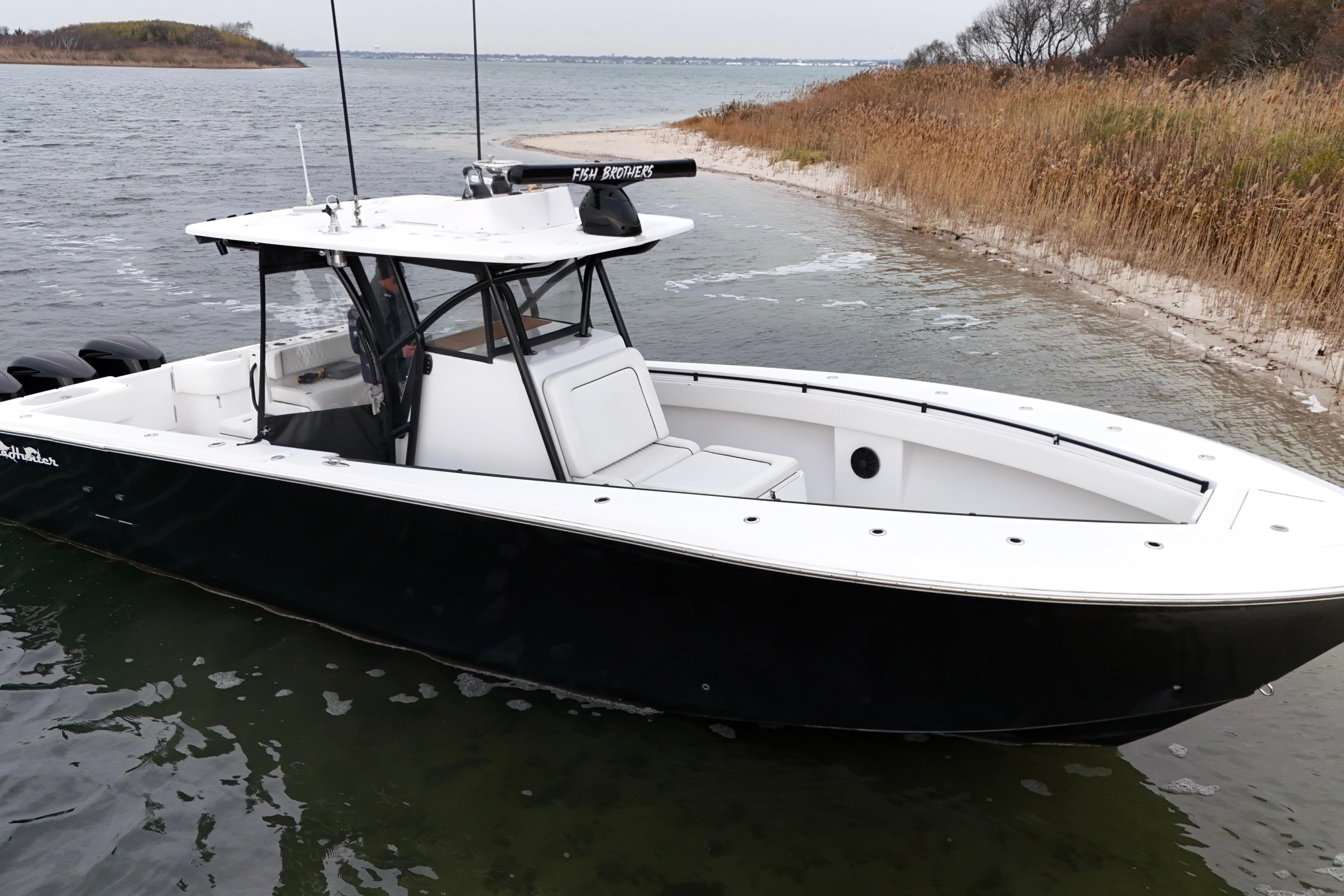 2016 Sea Hunter 35 Tournament boat docked near a sandy shoreline.
