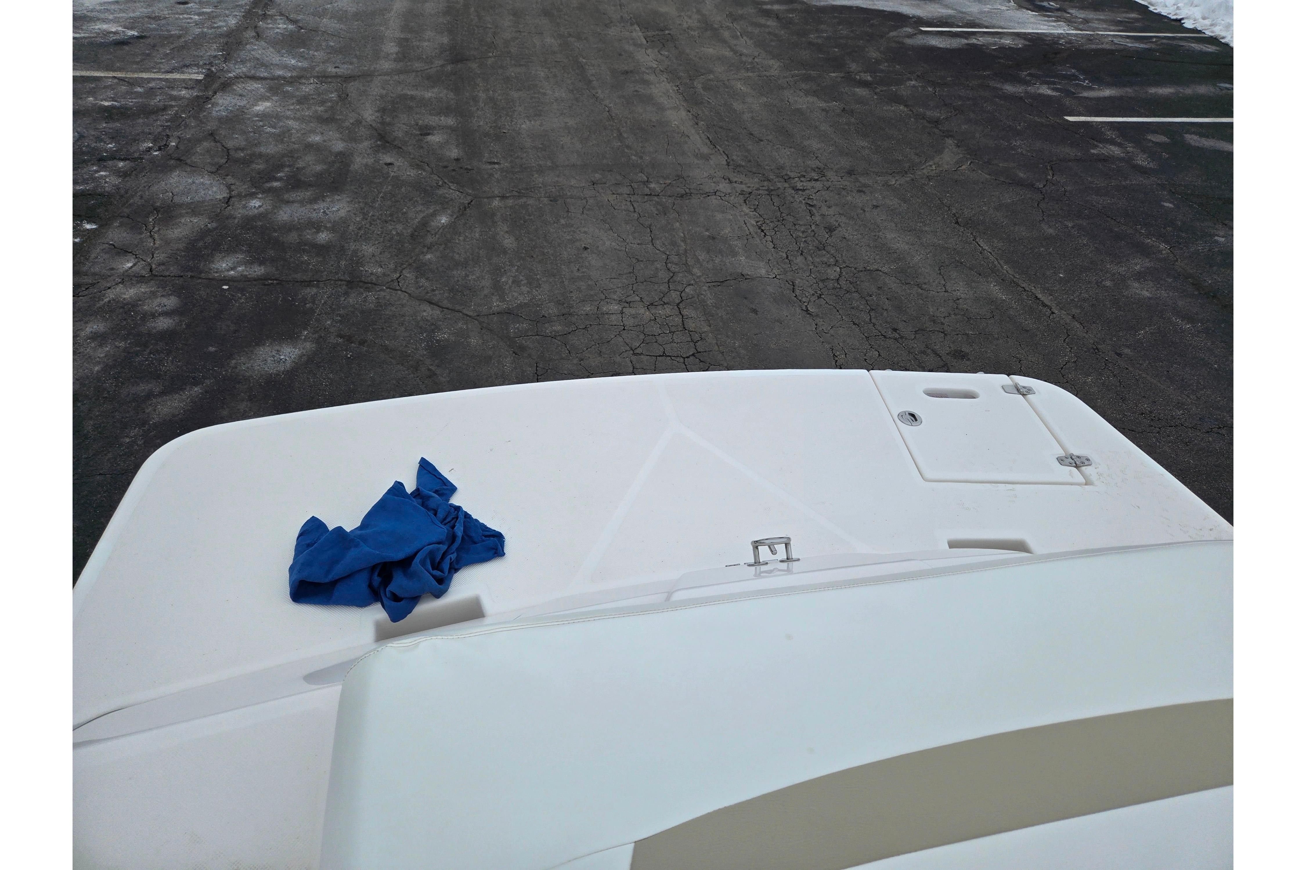 2015 Regal 1900 ES Bowrider boat deck with blue cloth on pavement background.