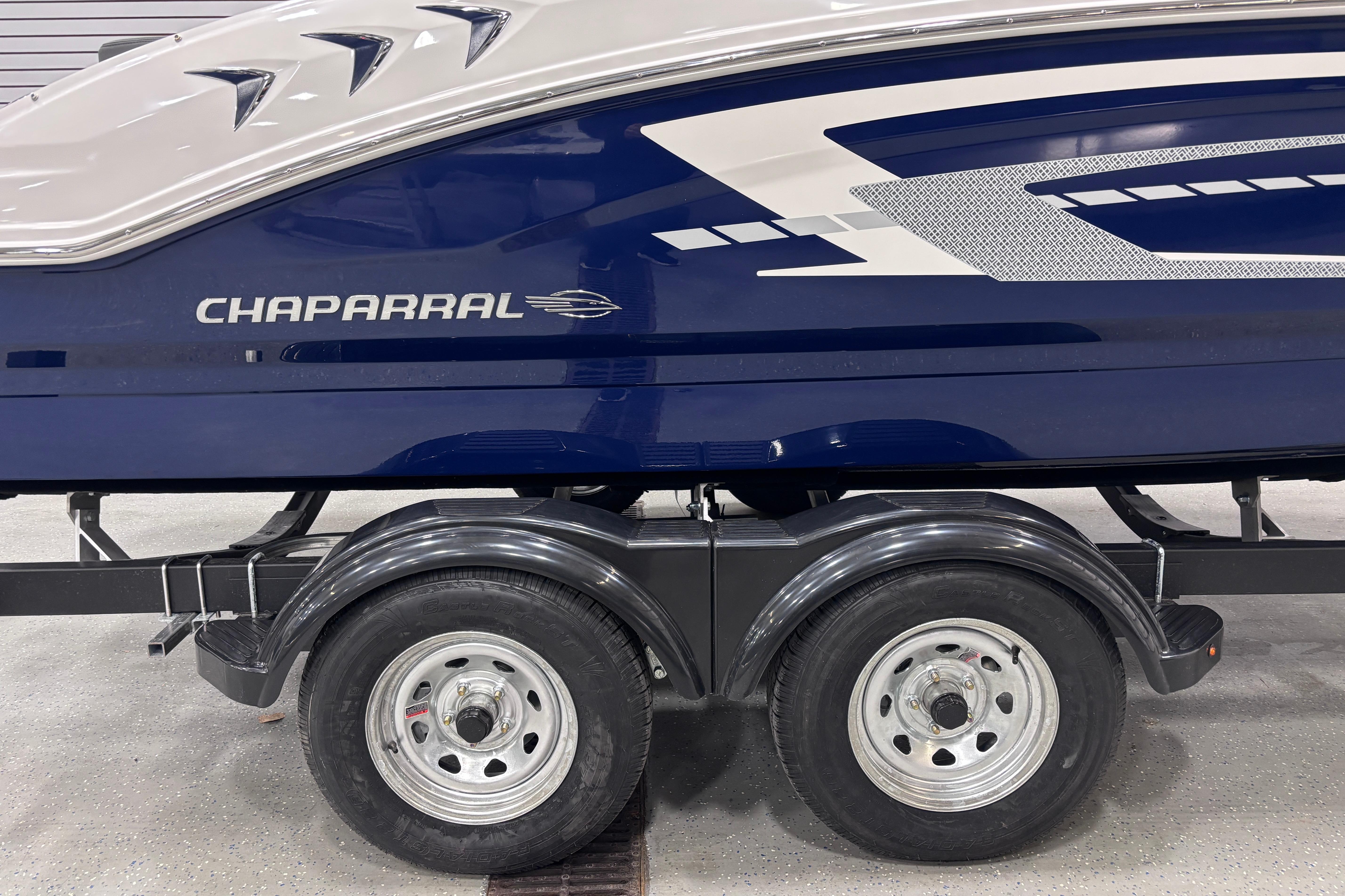 2026 Chaparral 21 SSi boat on trailer, featuring sleek blue and white design.