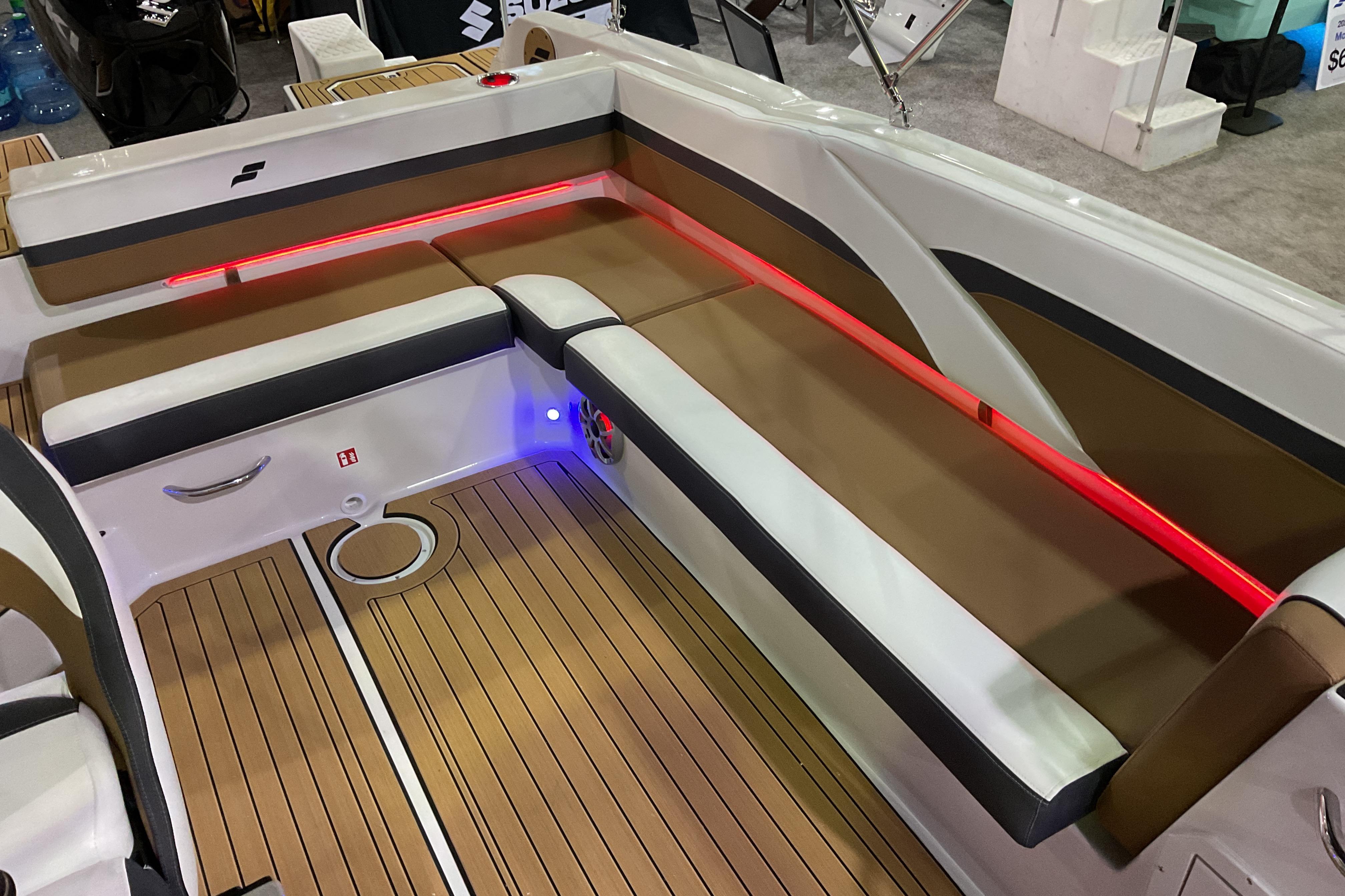 2026 Starcraft SVX 211 OB boat interior with brown seating, red LED lighting, and wood-style flooring.
