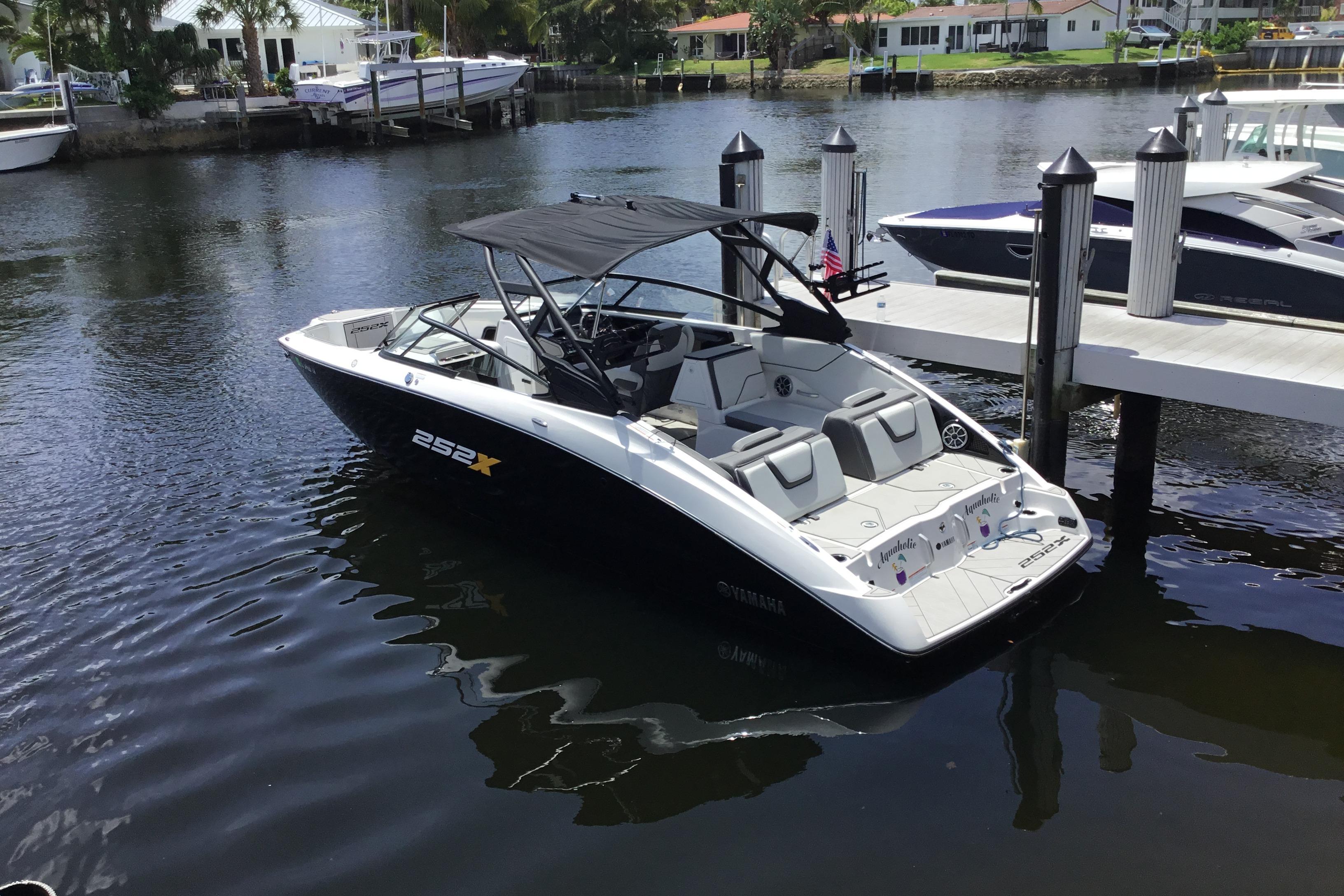 2023 Yamaha Boats 252XE docked in a serene marina setting.