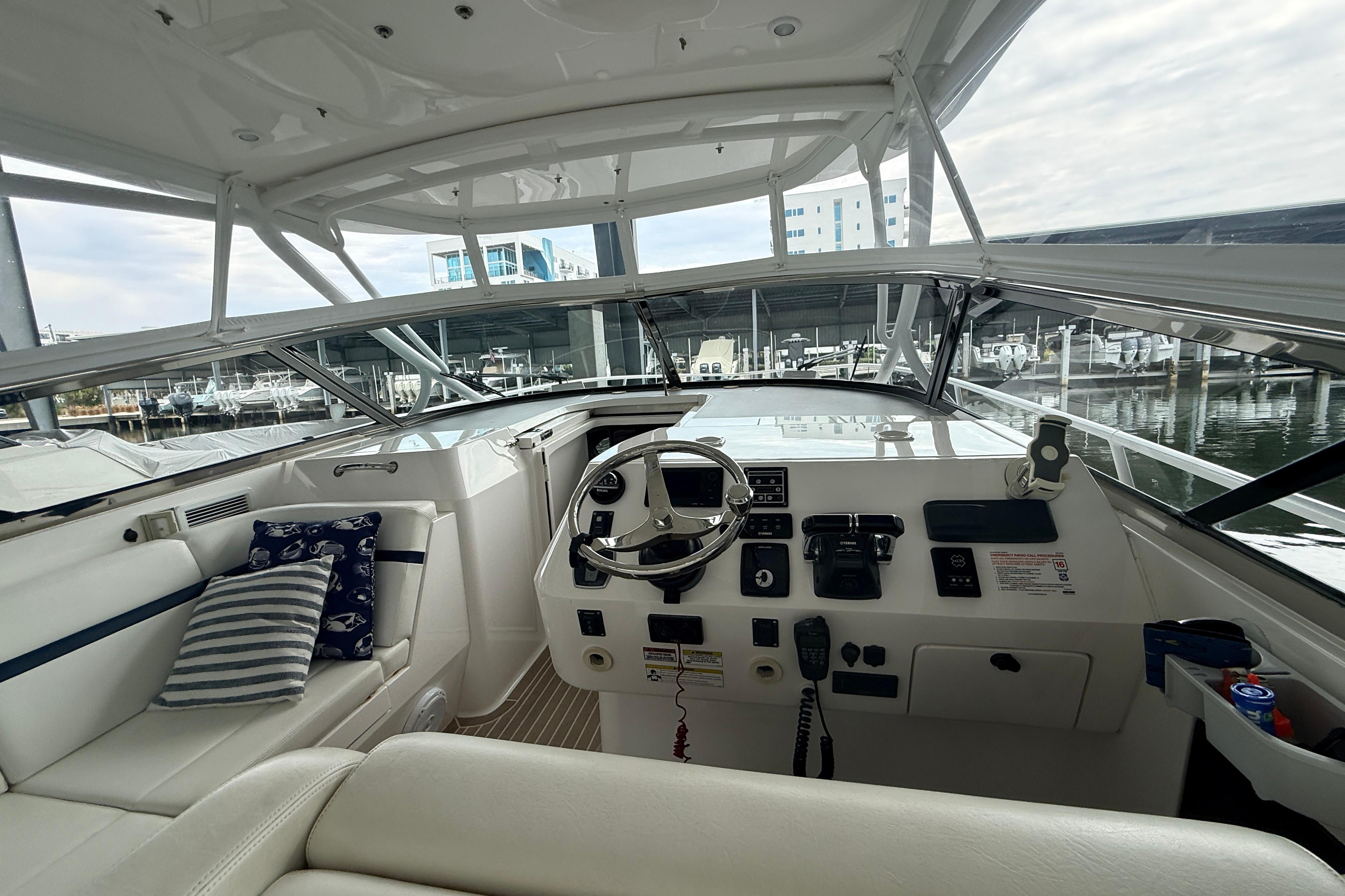 Cockpit of 2016 Intrepid 430 Sport Yacht with steering wheel and control panel.