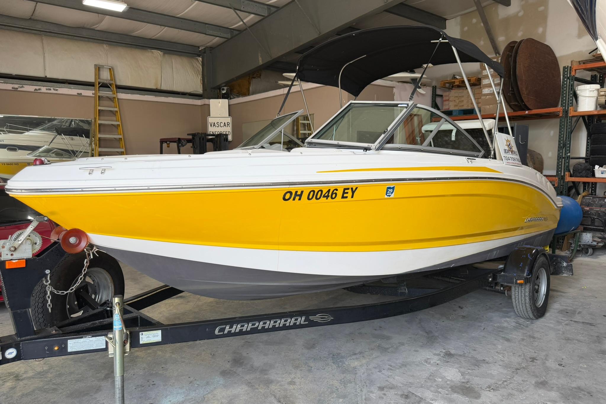 2012 Chaparral 19 Sport H2O boat in a garage, yellow and white exterior.