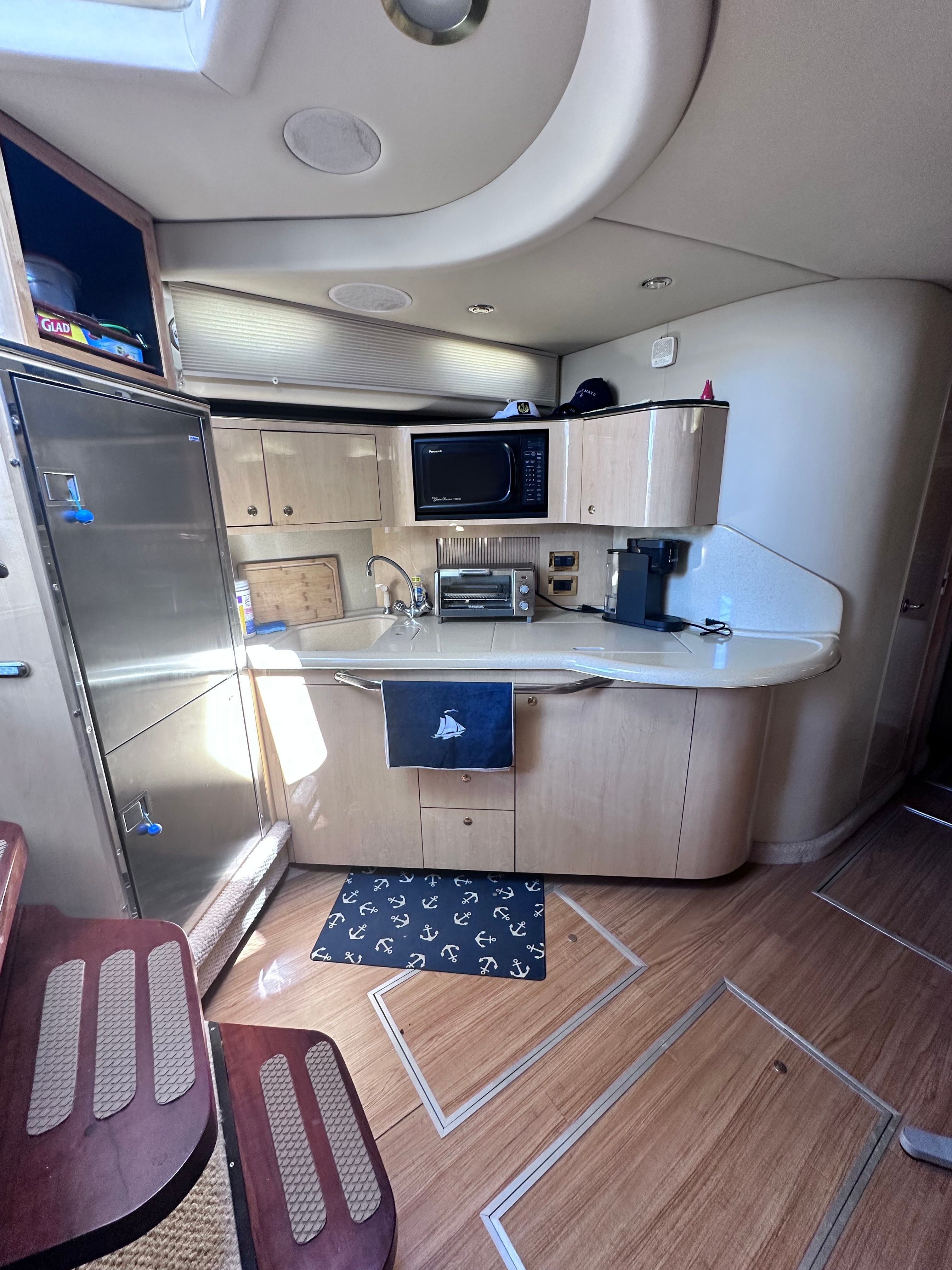Interior of 2000 Sea Ray 380 Sundancer yacht kitchen with modern appliances and wood flooring.