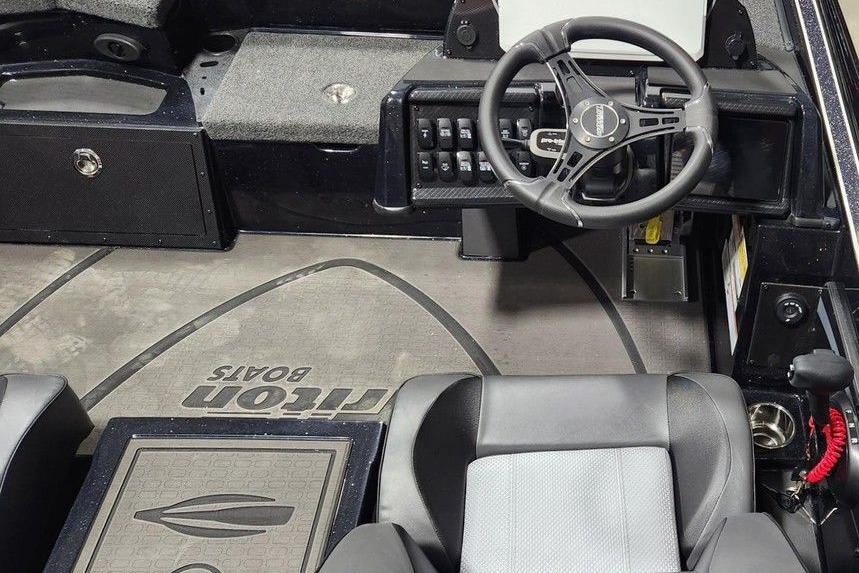 Interior of 2026 Triton 20XP Patriot boat with steering wheel and seating.