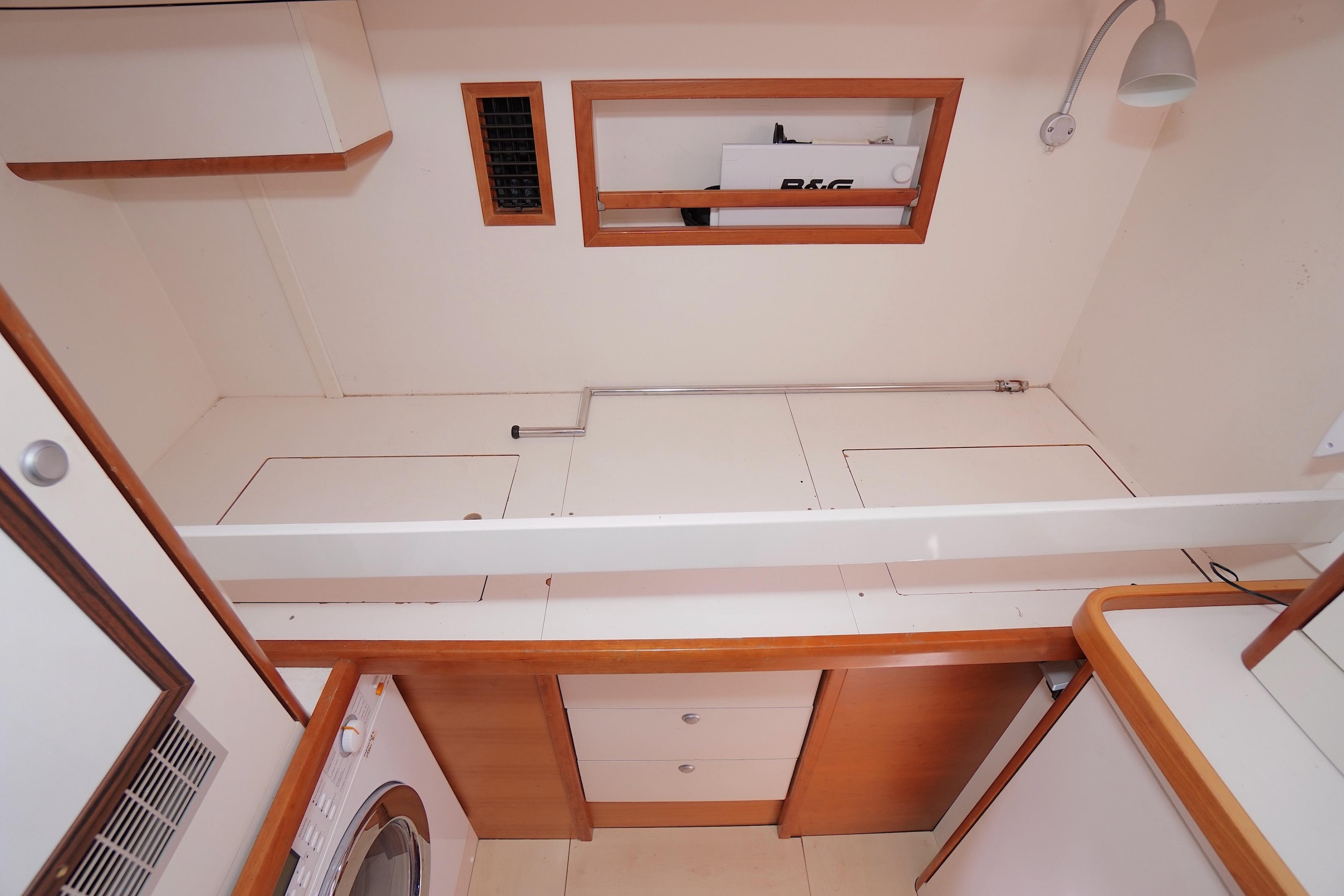 Laundry area in 2009 Hanse 630e yacht with washing machine and storage cabinets.