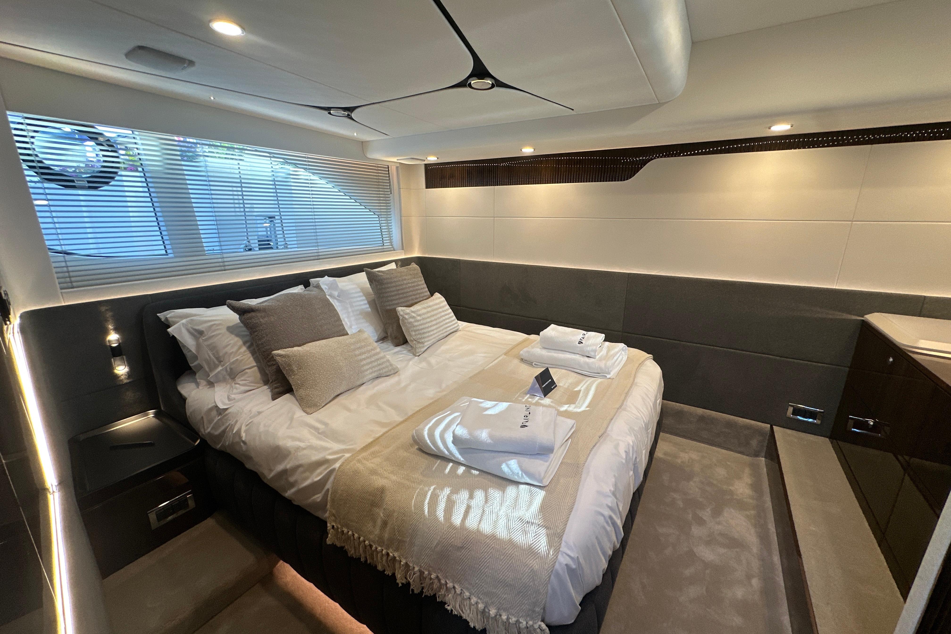 Luxurious bedroom interior of 2026 Fairline Targa 47 GT yacht with elegant bedding.