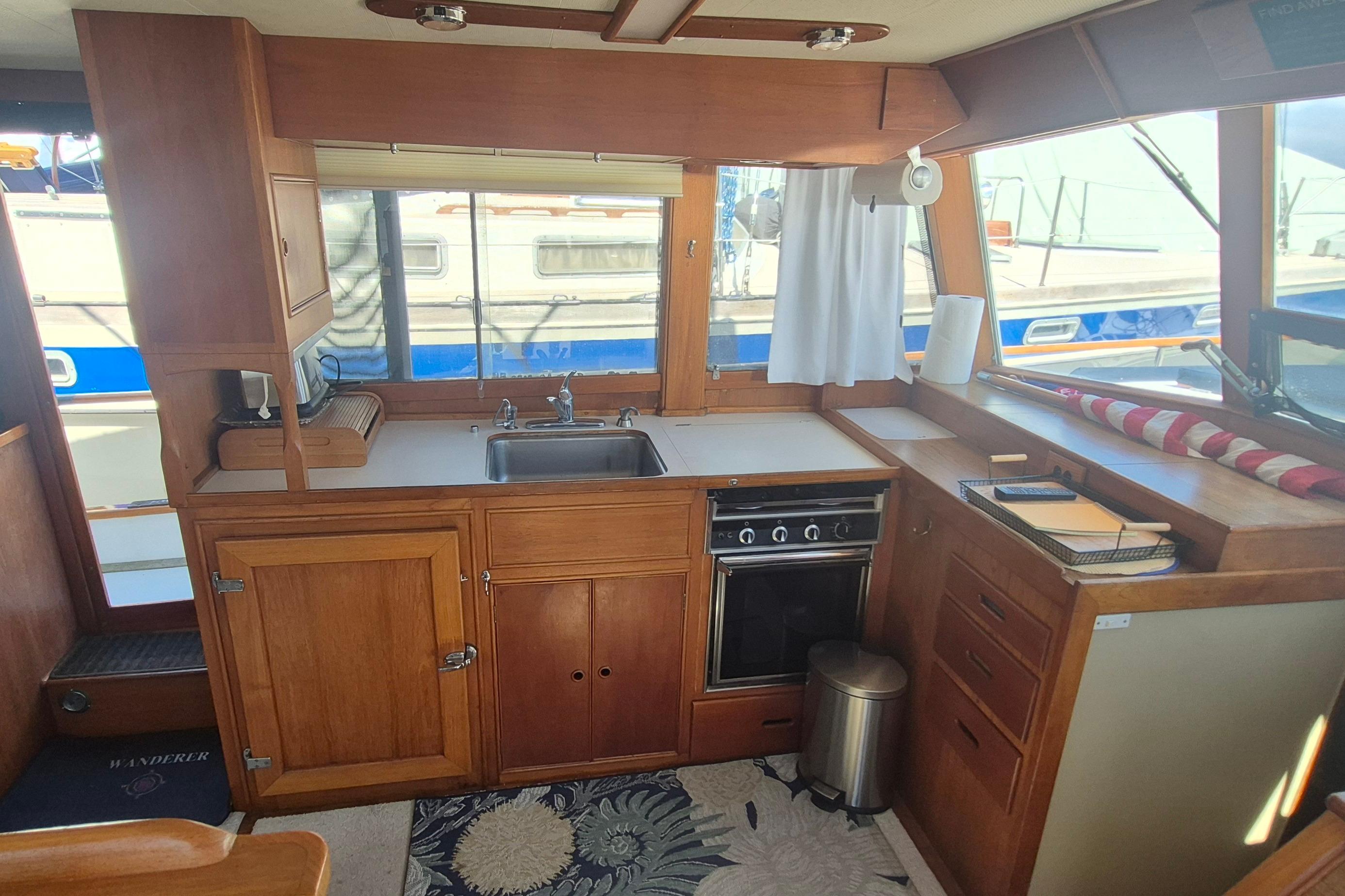 Interior of 1983 Grand Banks 42 Motoryacht kitchen with wooden cabinetry and appliances.
