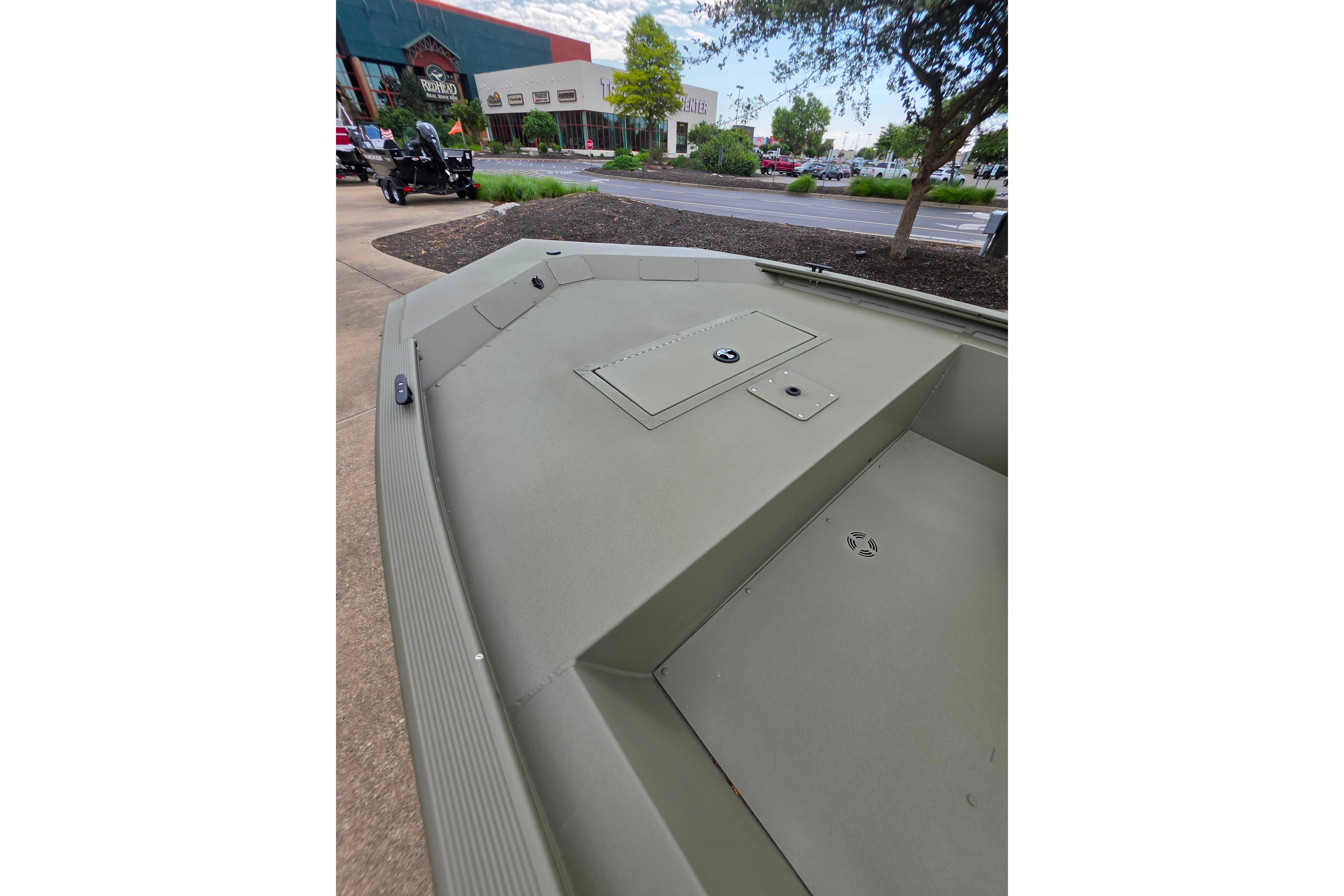 2026 Tracker Grizzly 1648 SC boat displayed outdoors near a store.