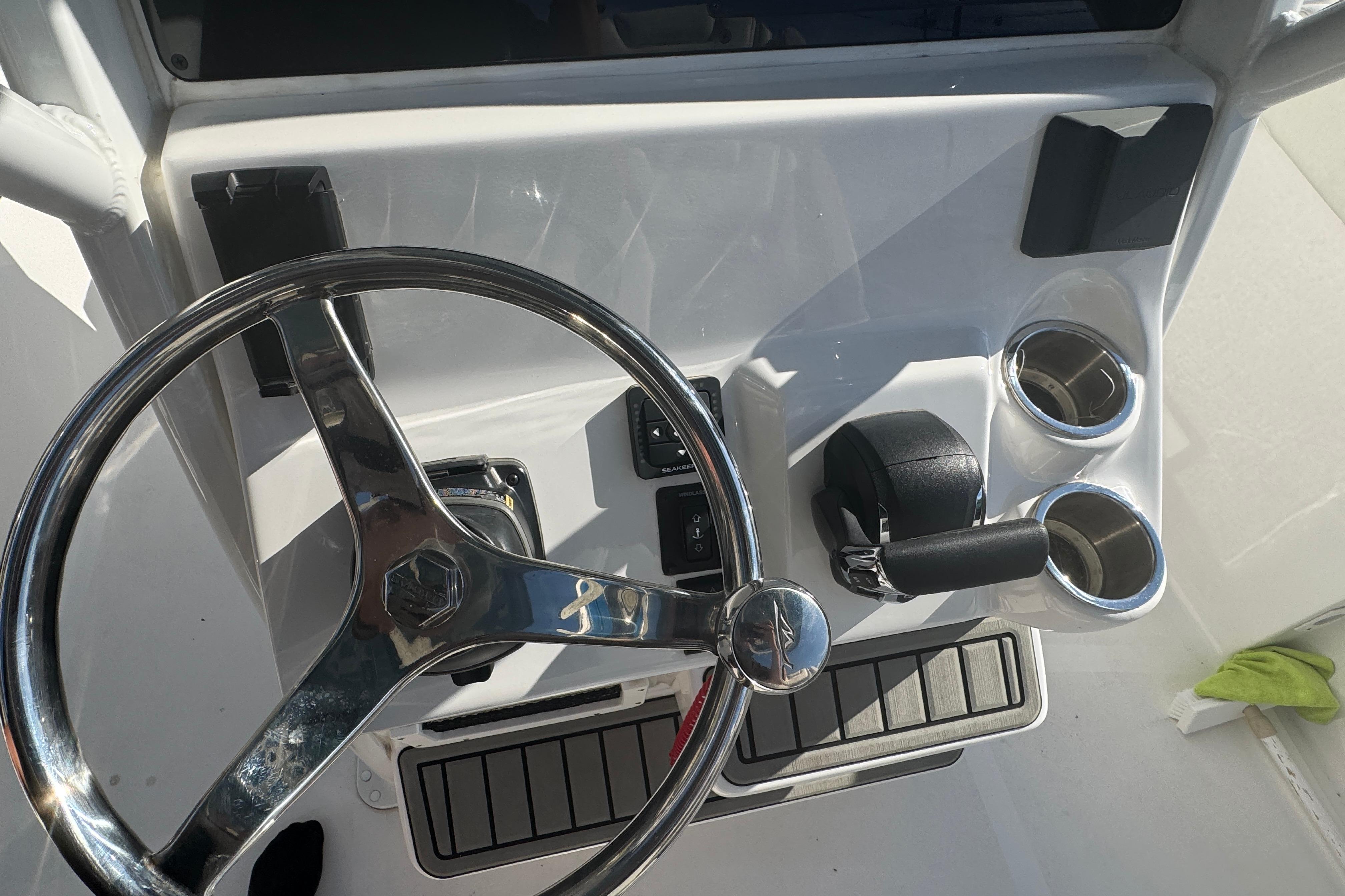 Steering console of 2025 Tidewater 232 LXF boat with chrome accents and cup holders.