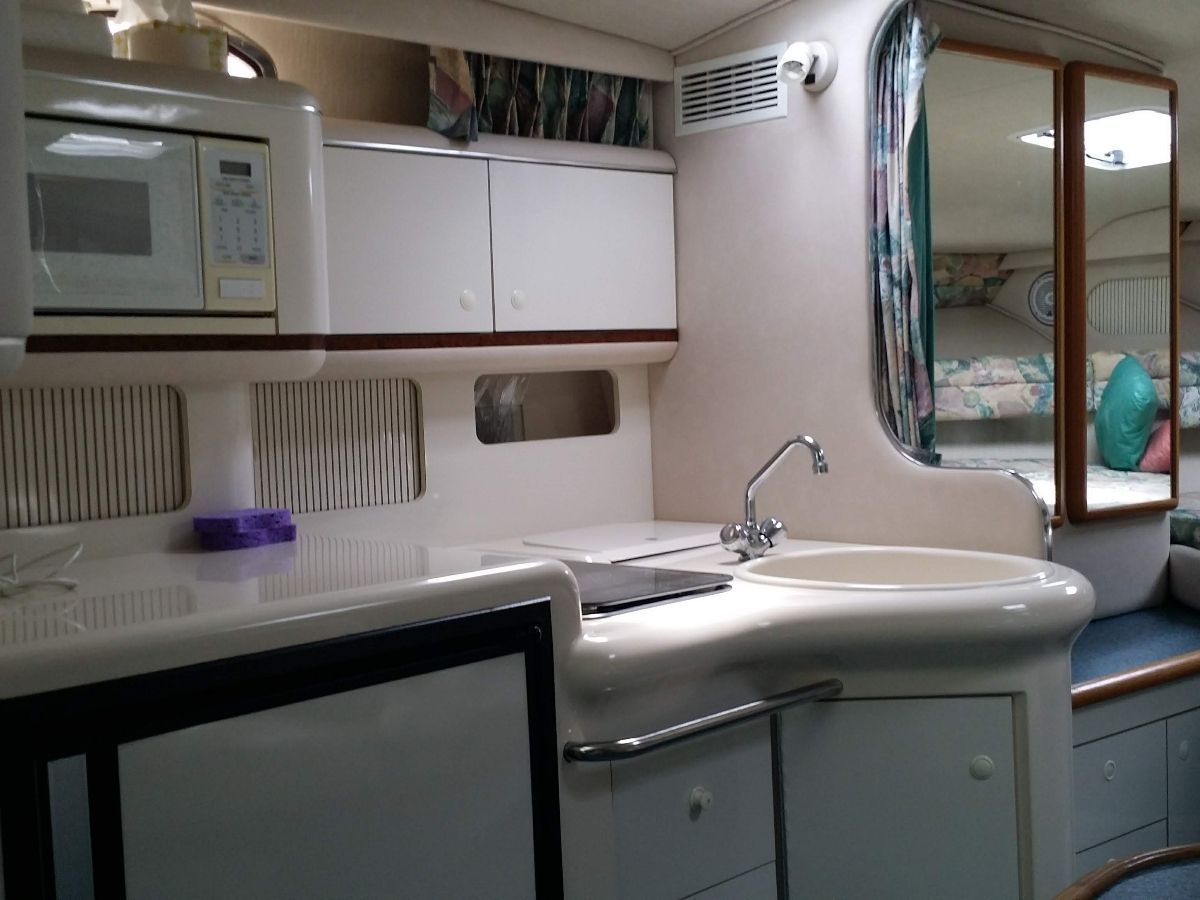 Interior of the 1995 Sea Ray Sundancer 330 featuring a kitchen and sleeping area.