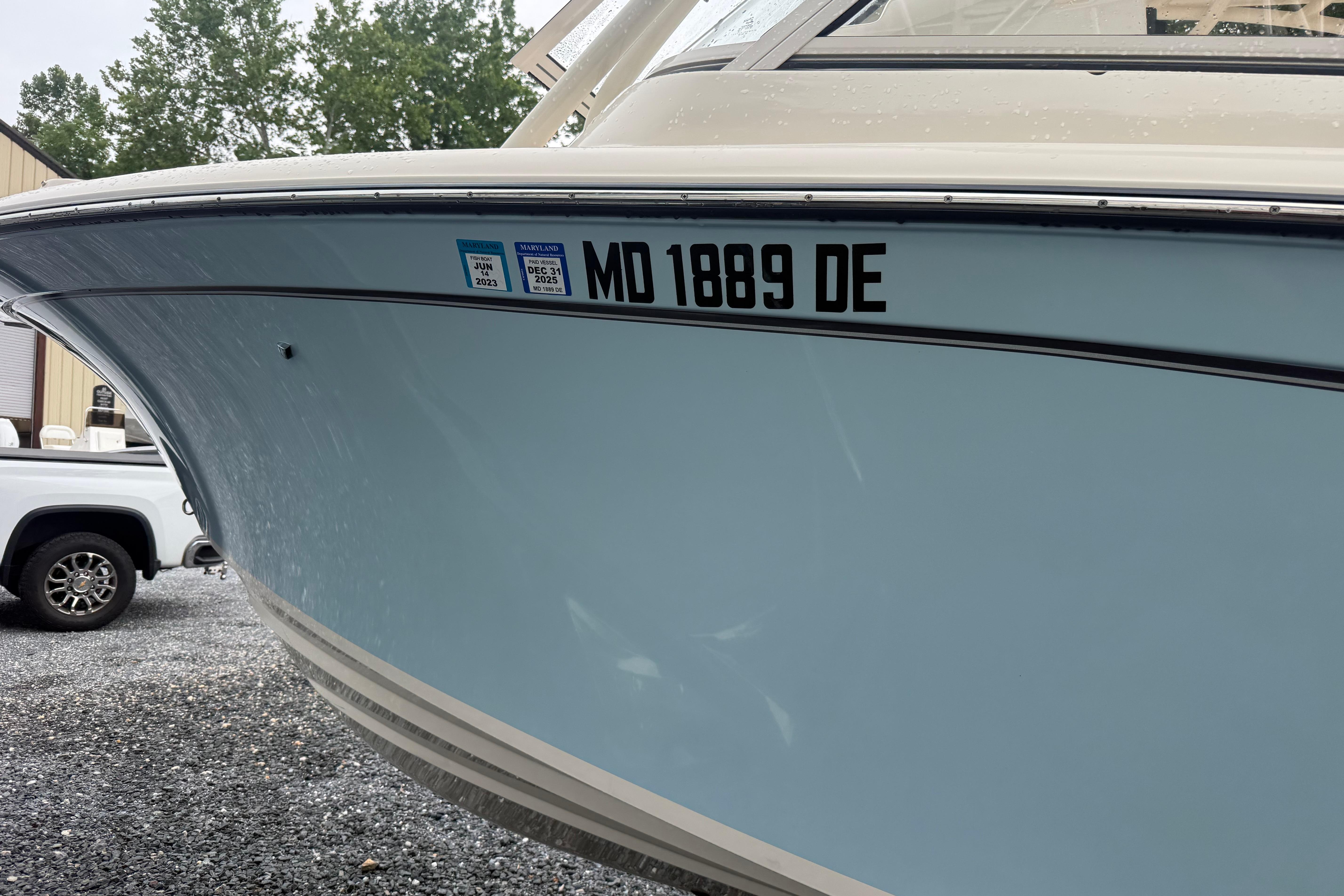 2022 Grady-White Freedom 235 boat with registration MD 1889 DE, parked on gravel.