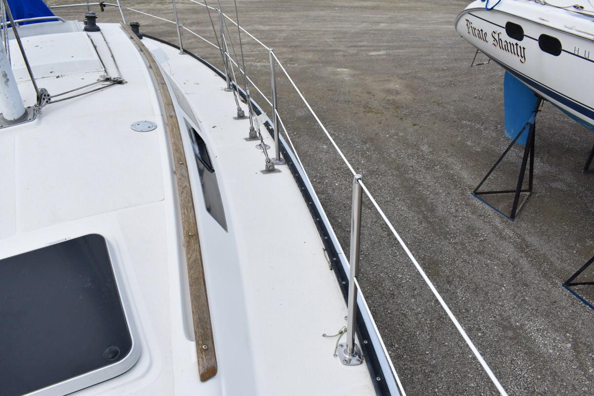 Deck view of a 1987 S2 9.2A yacht with railing and wooden trim.